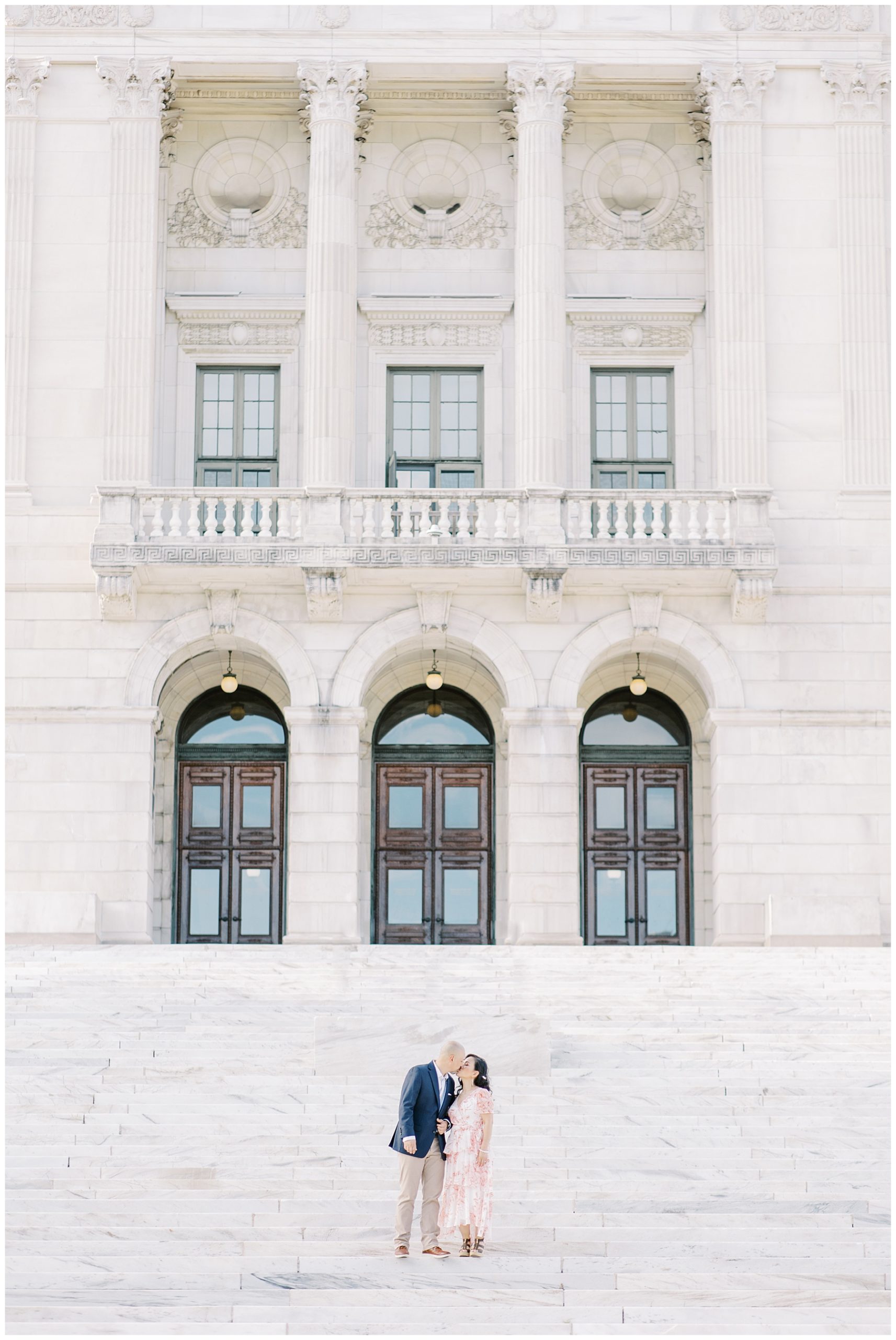couple kiss in front of charming building in Rhode Island