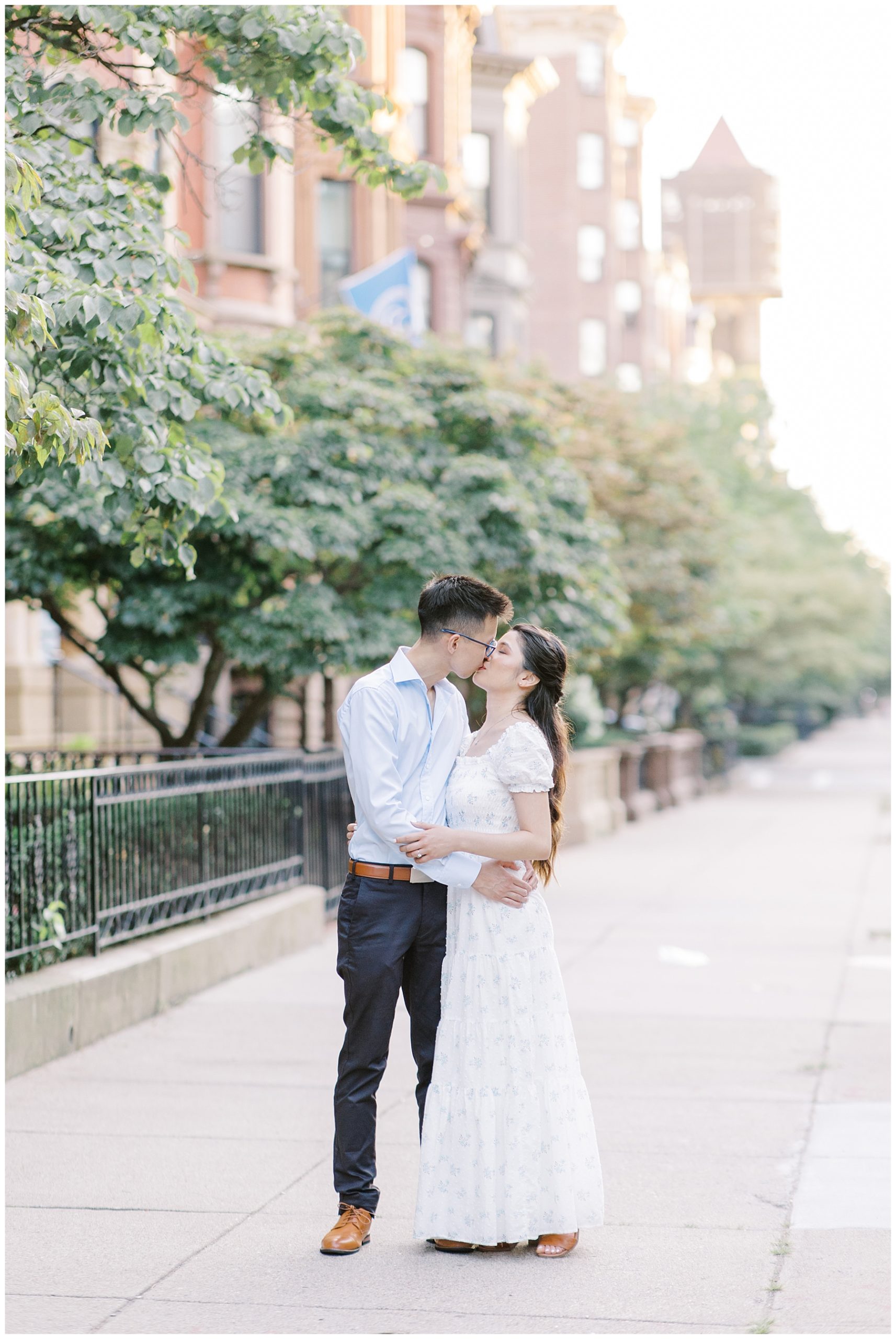 couple kiss on the sidewalk during Boston Summer Engagement Session