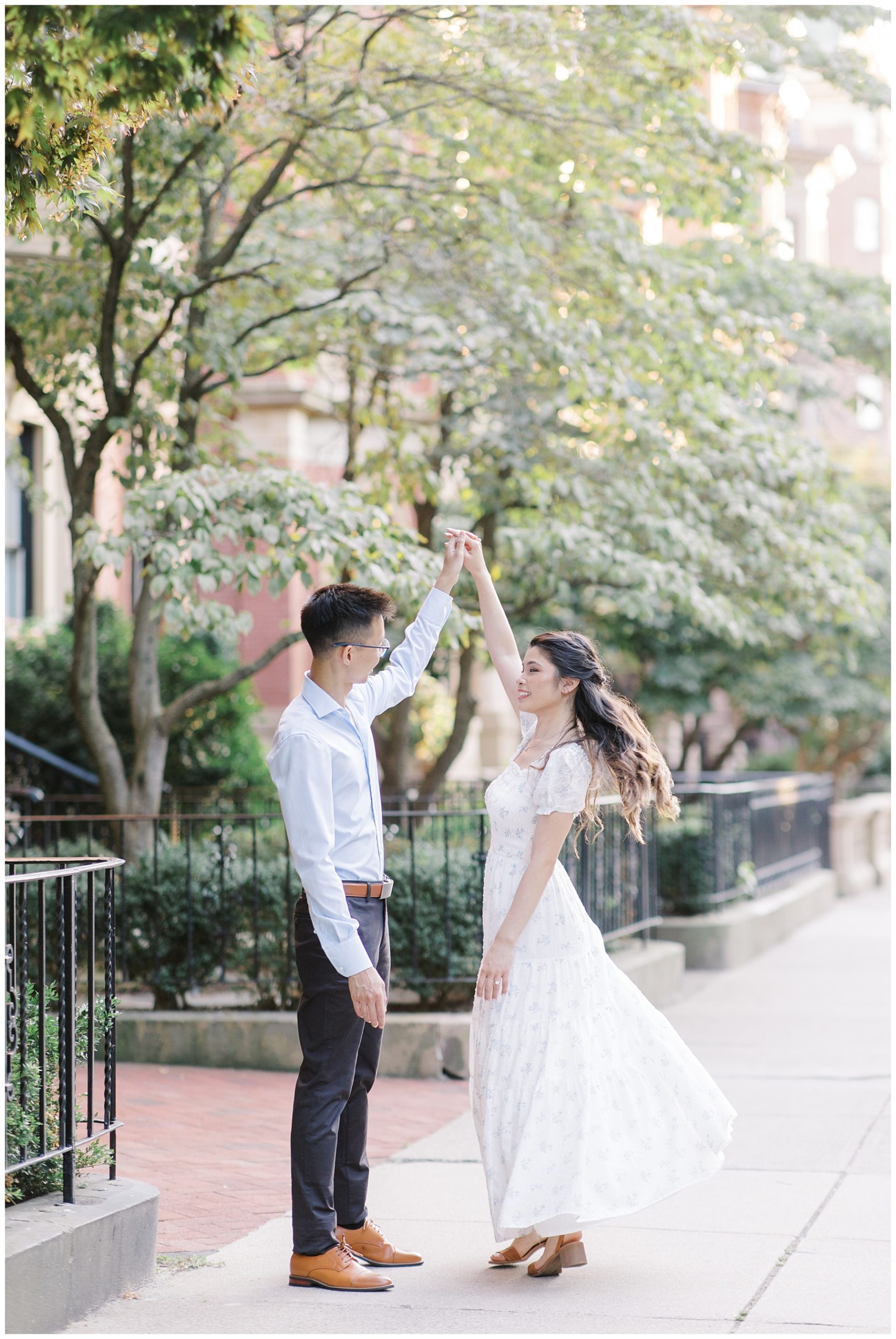 man twirls his fiance during engagement session