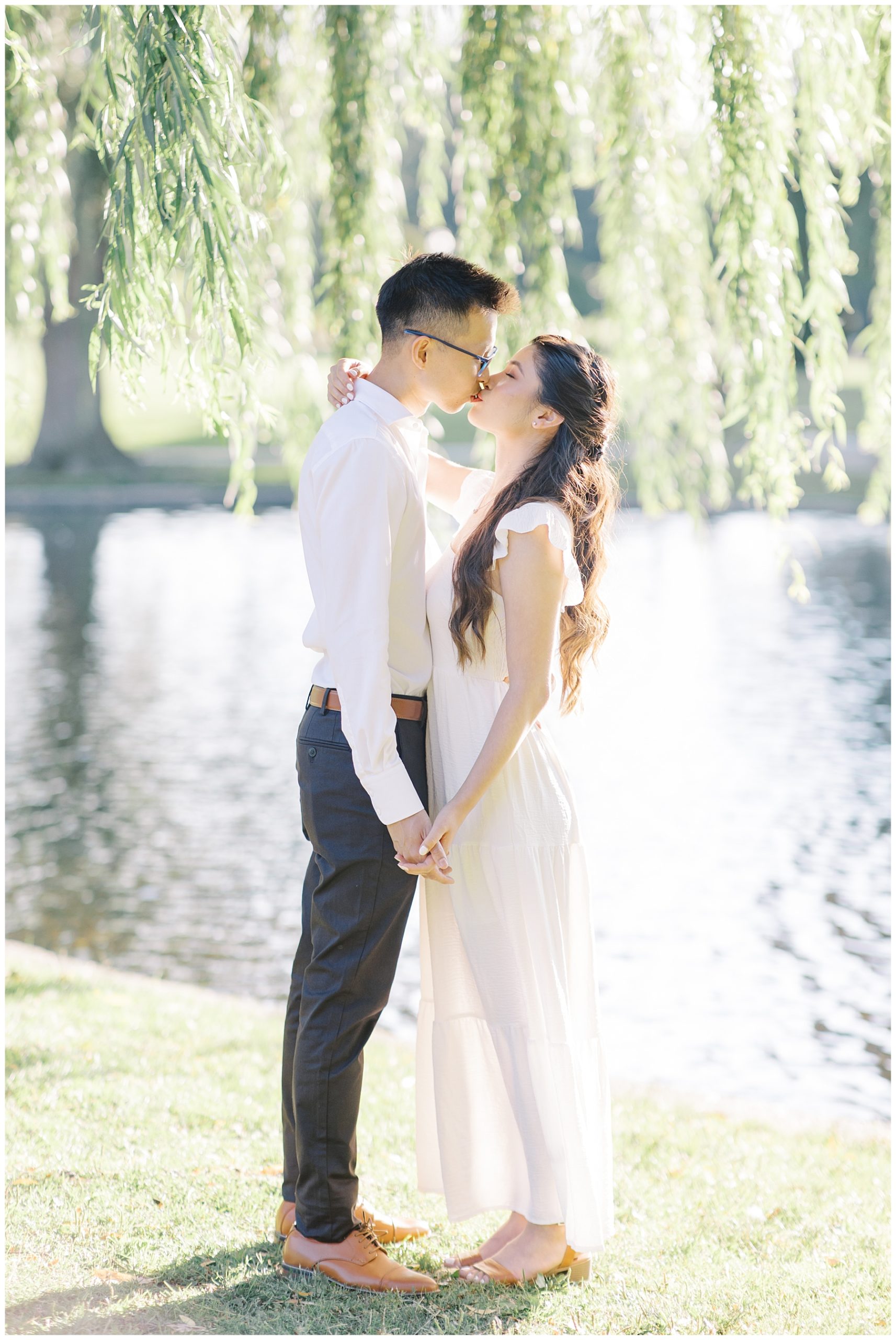 couple kiss under a willow tree