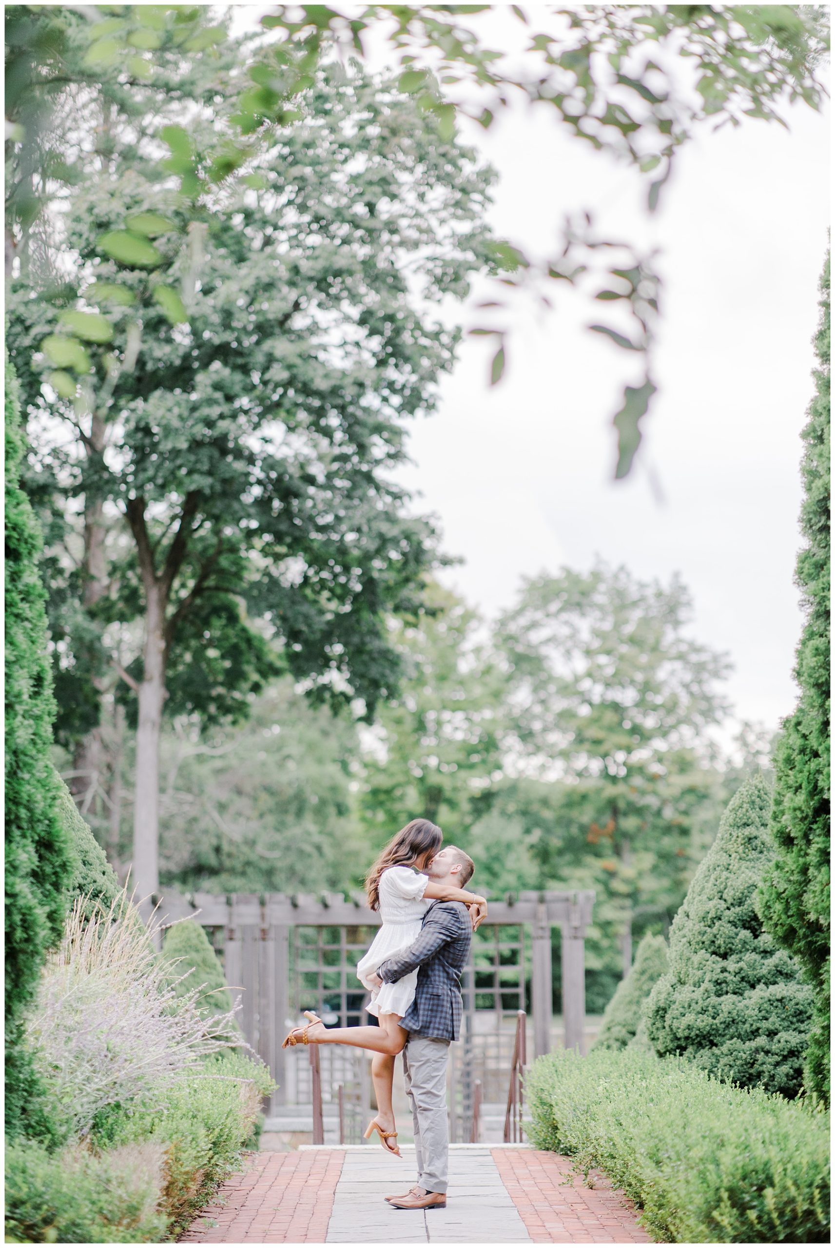 man lifts his fiance and kisses her during Romantic Boston Engagement Session