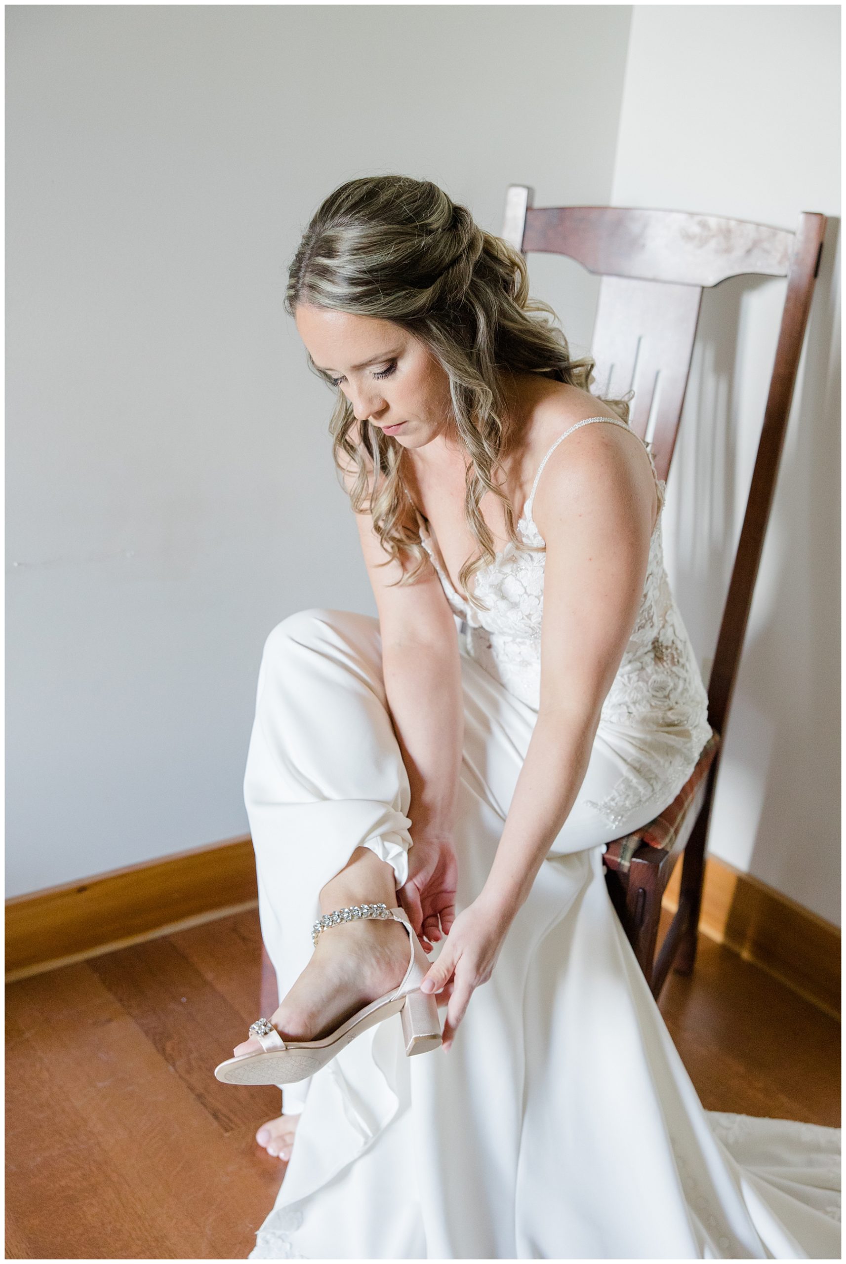 stunning bride puts on wedding shoes