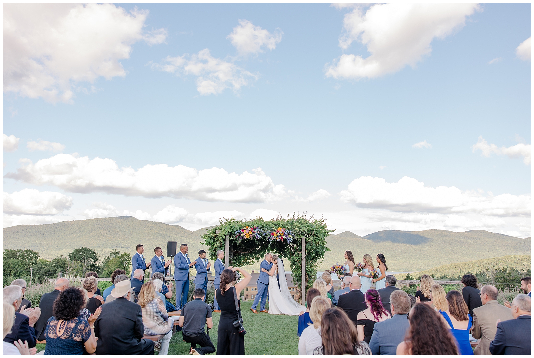 Couple kiss at dreamy vermont wedding ceremony overlooking the green moutnains
