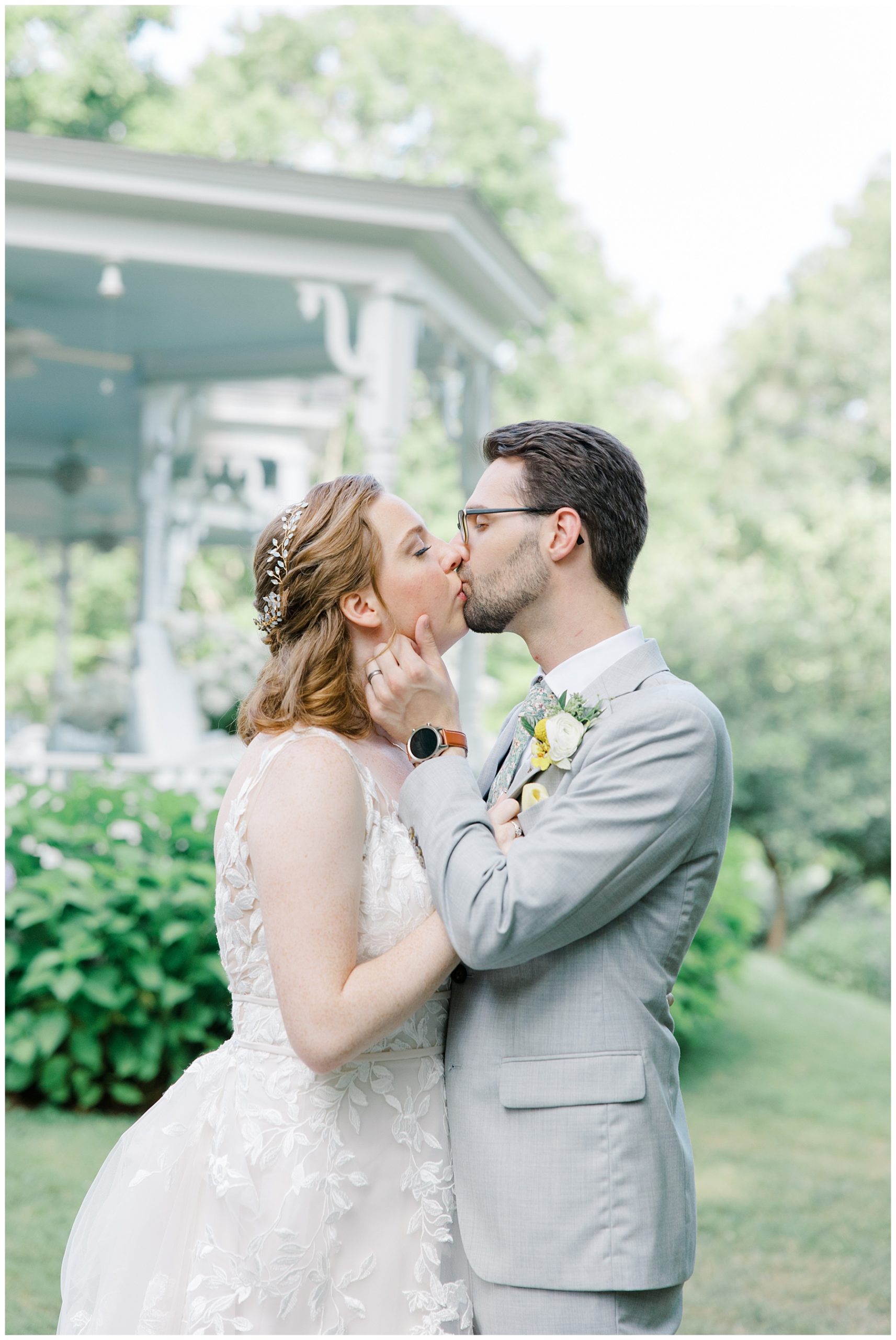 newlyweds kiss during wedding portraits 