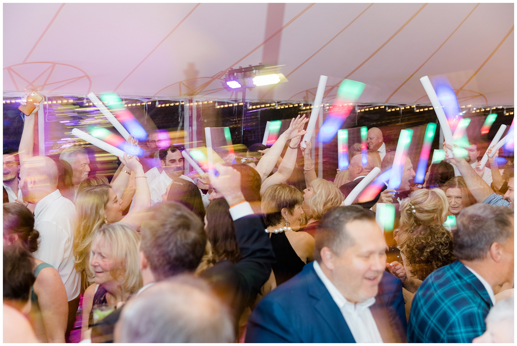 wedding guests wave glow stick at Willowdale Estate Fall Wedding reception 