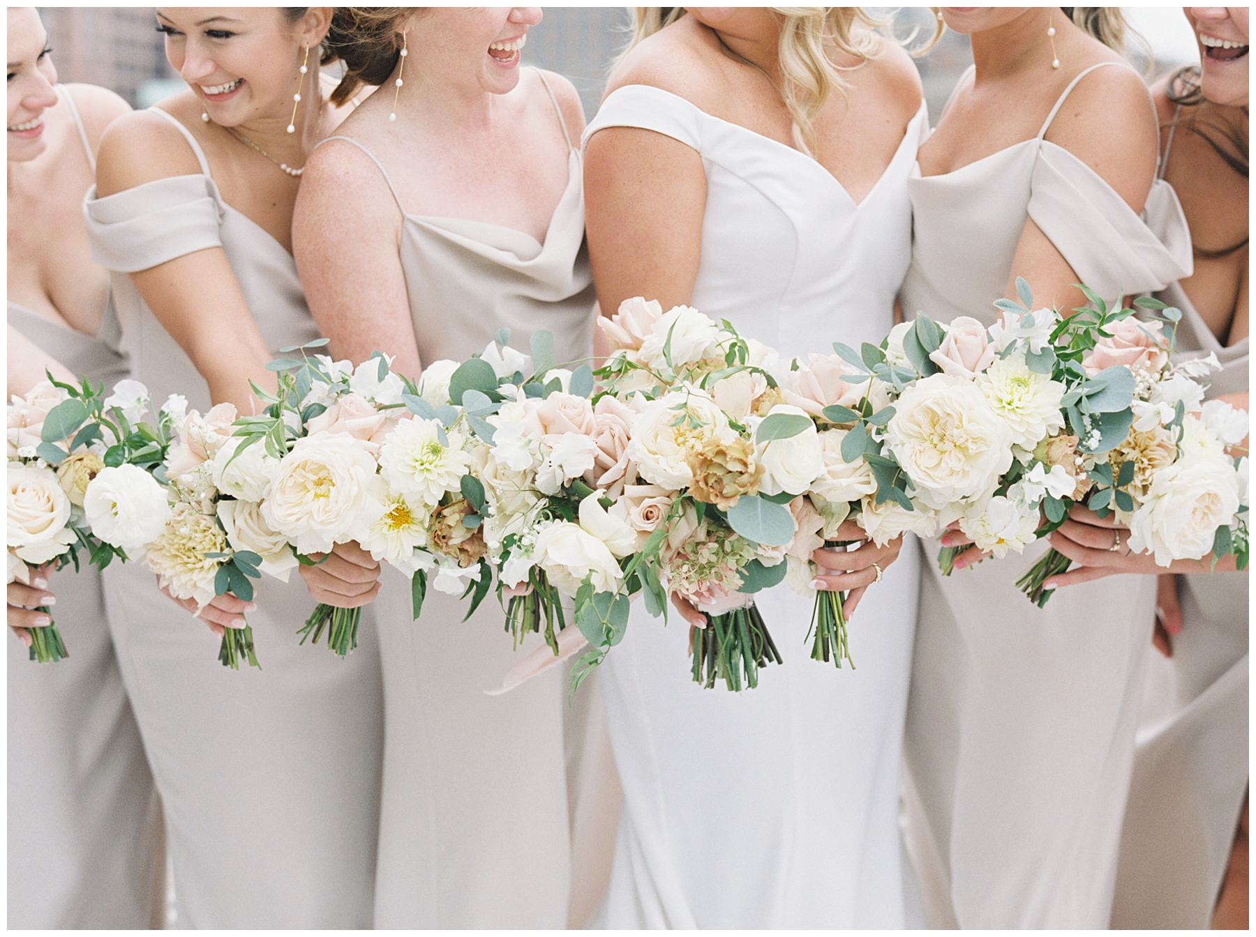 bride and bridesmaids in elegant dresses and light and neutral wedding flowers 