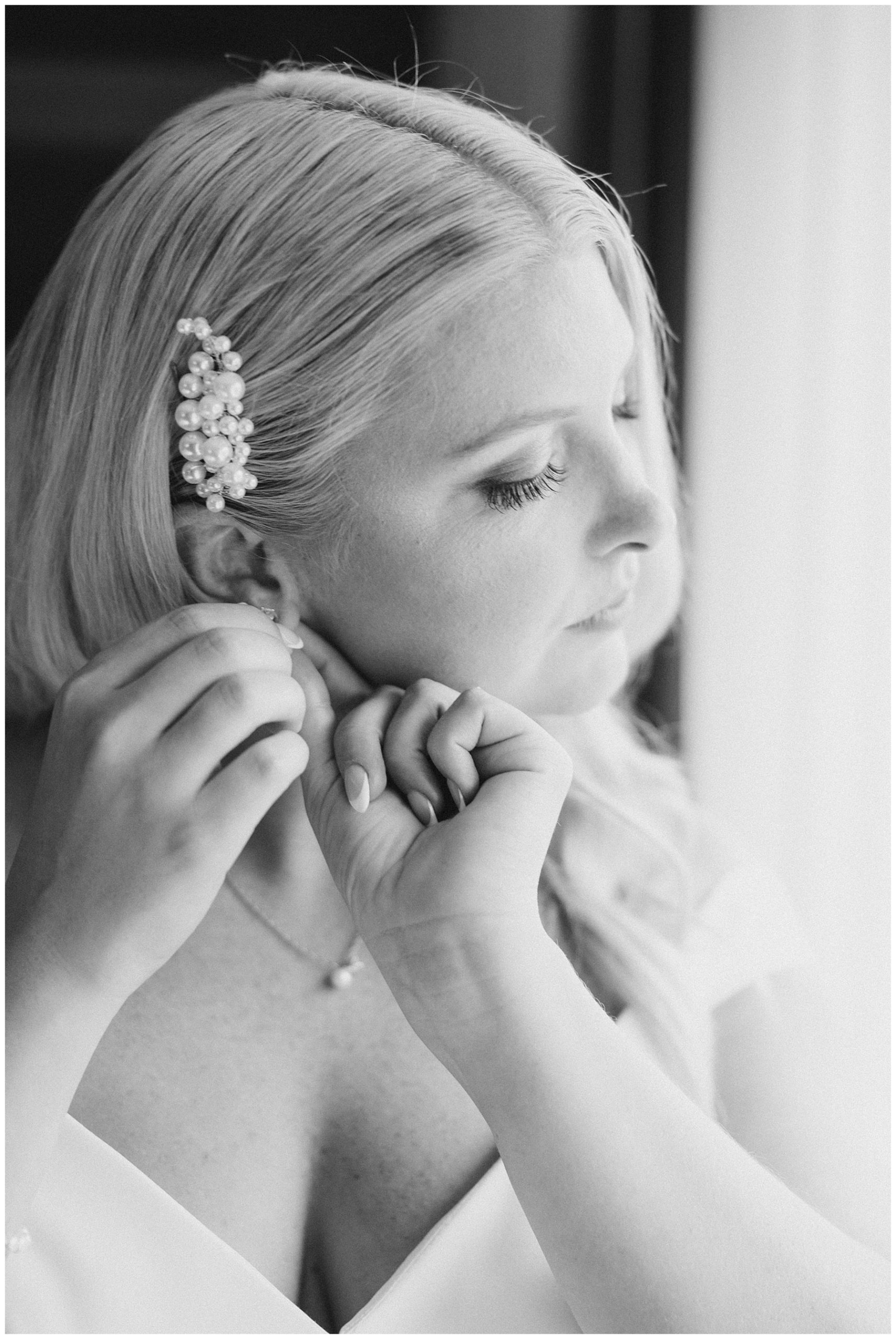 bride putting earrings in