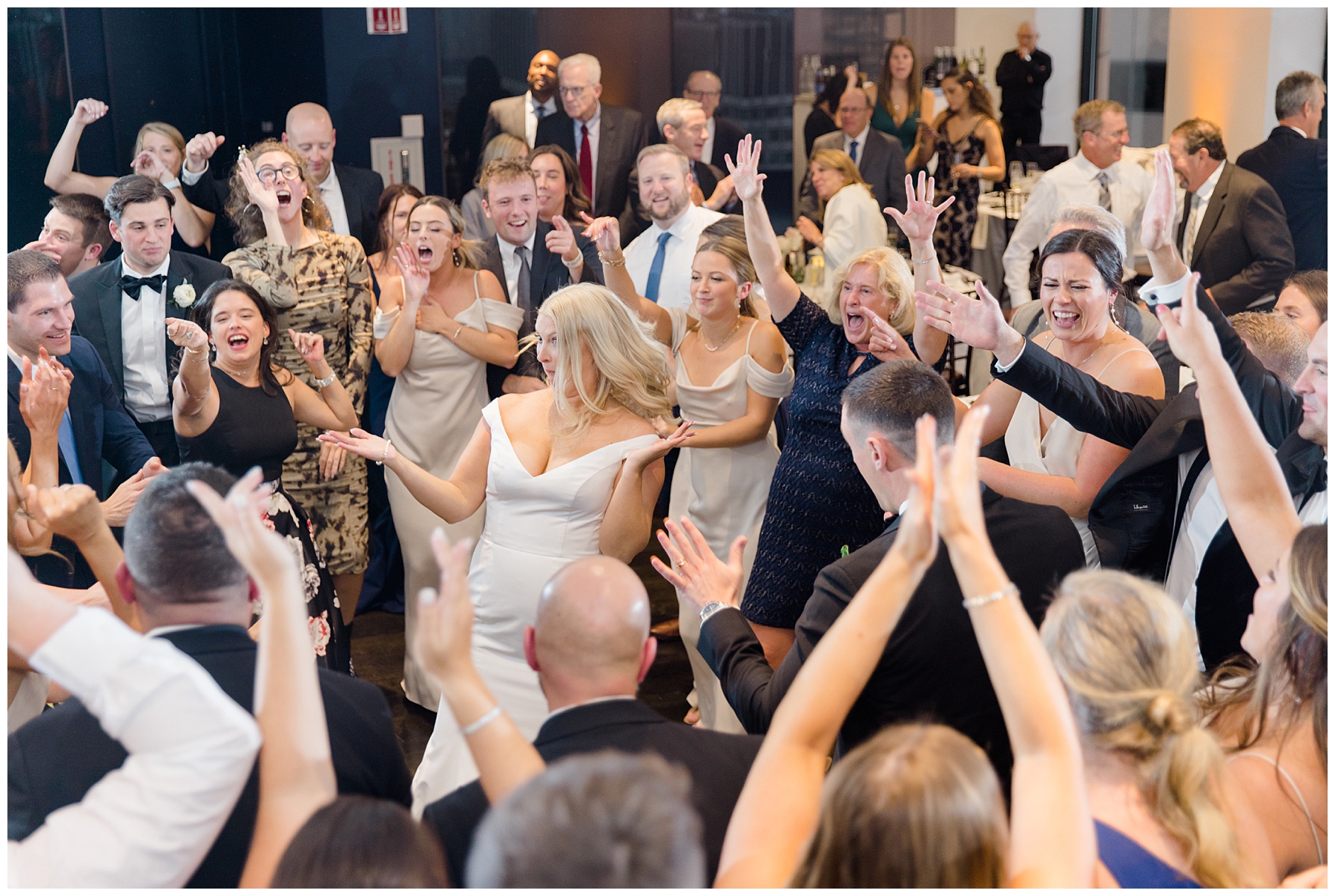 couple and wedding guests celebrate on dance floor