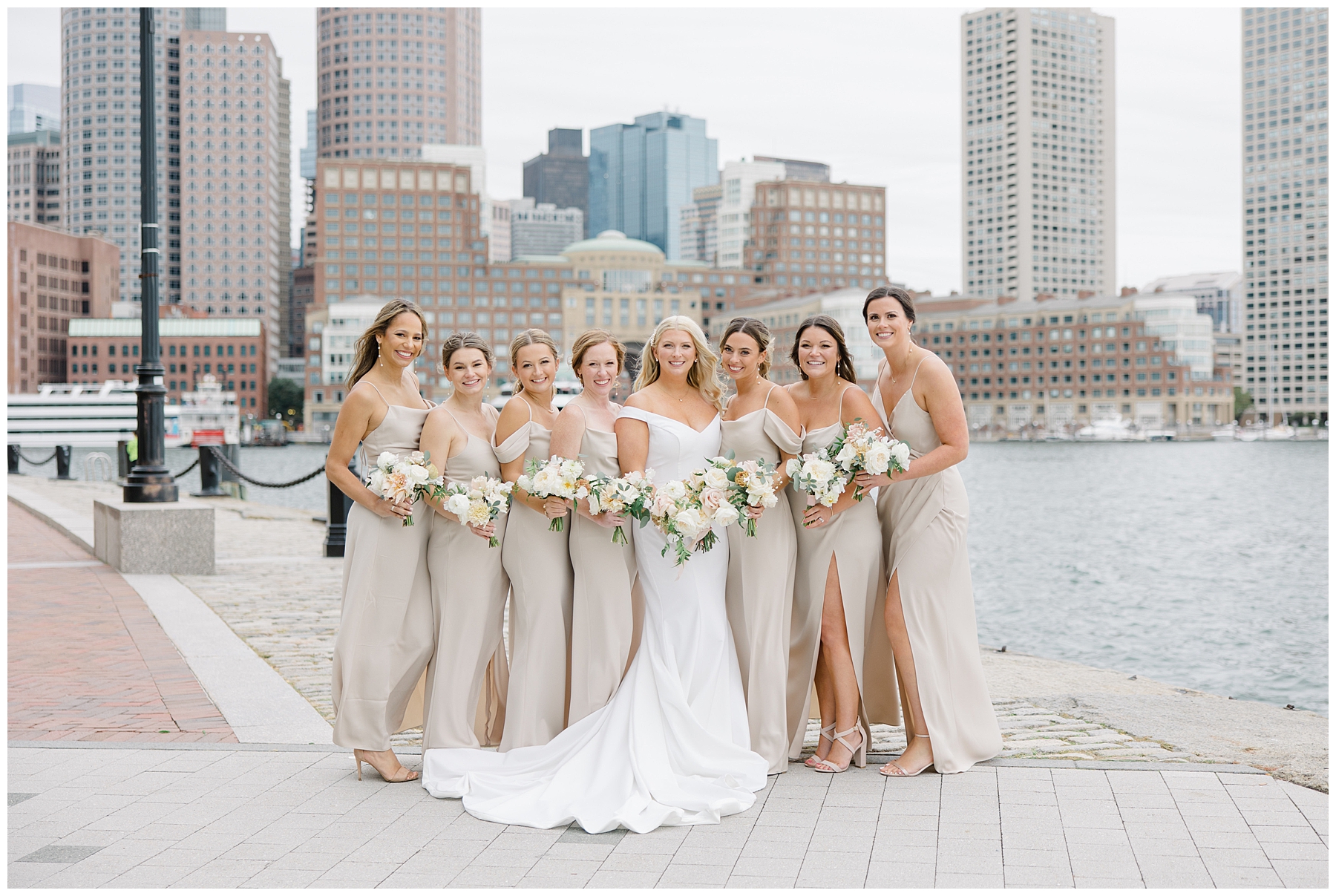 bride and bridesmaids in champagne colored dresses at Fan Pier Park in Boston
