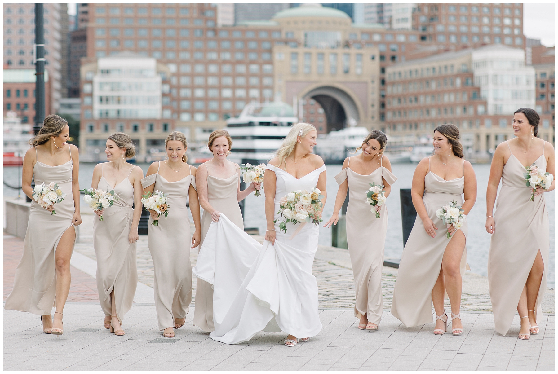 Bride walks with bridesmaids at Fan Pier Park in Boston