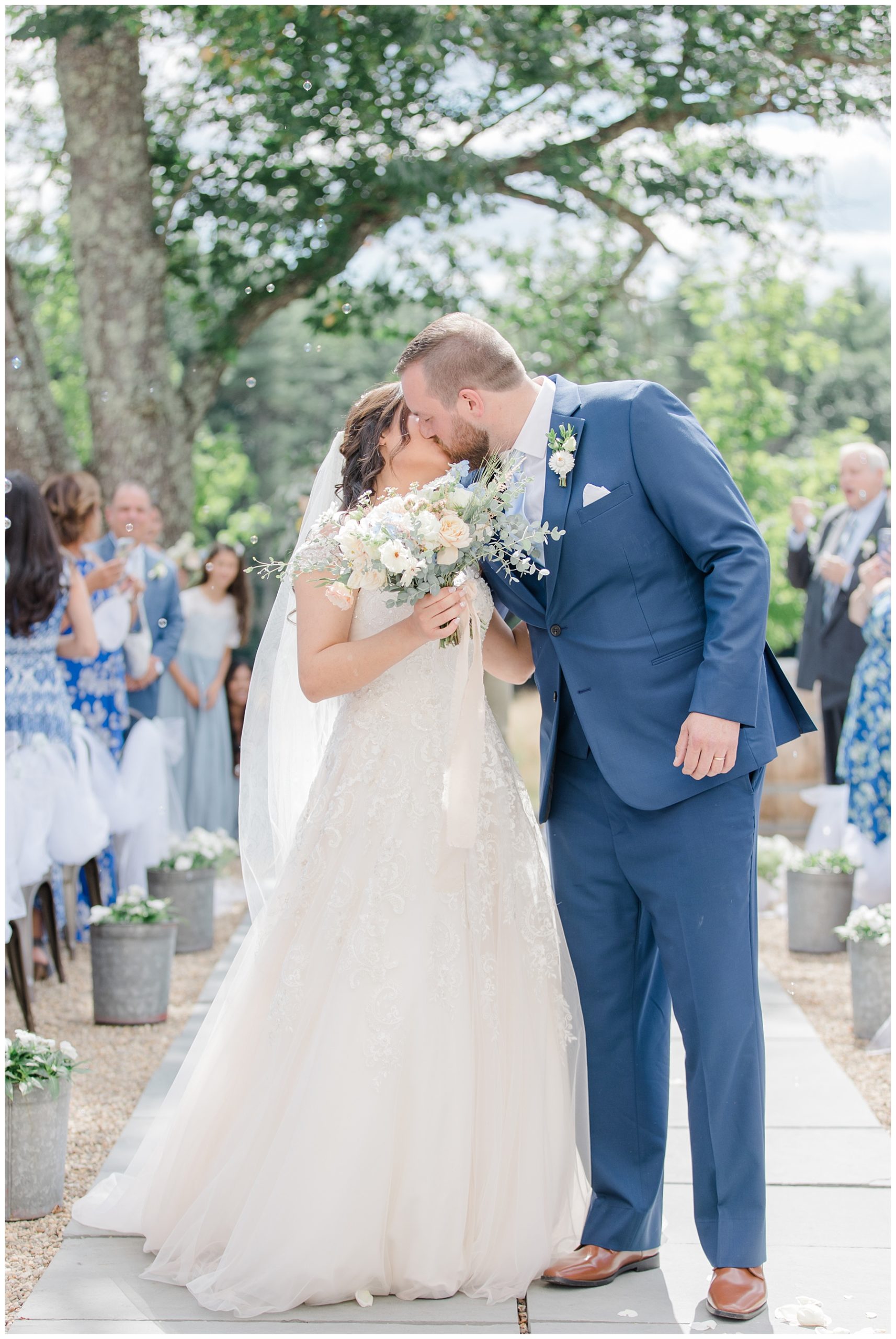 newlyweds kiss as they walk down the aisle together 