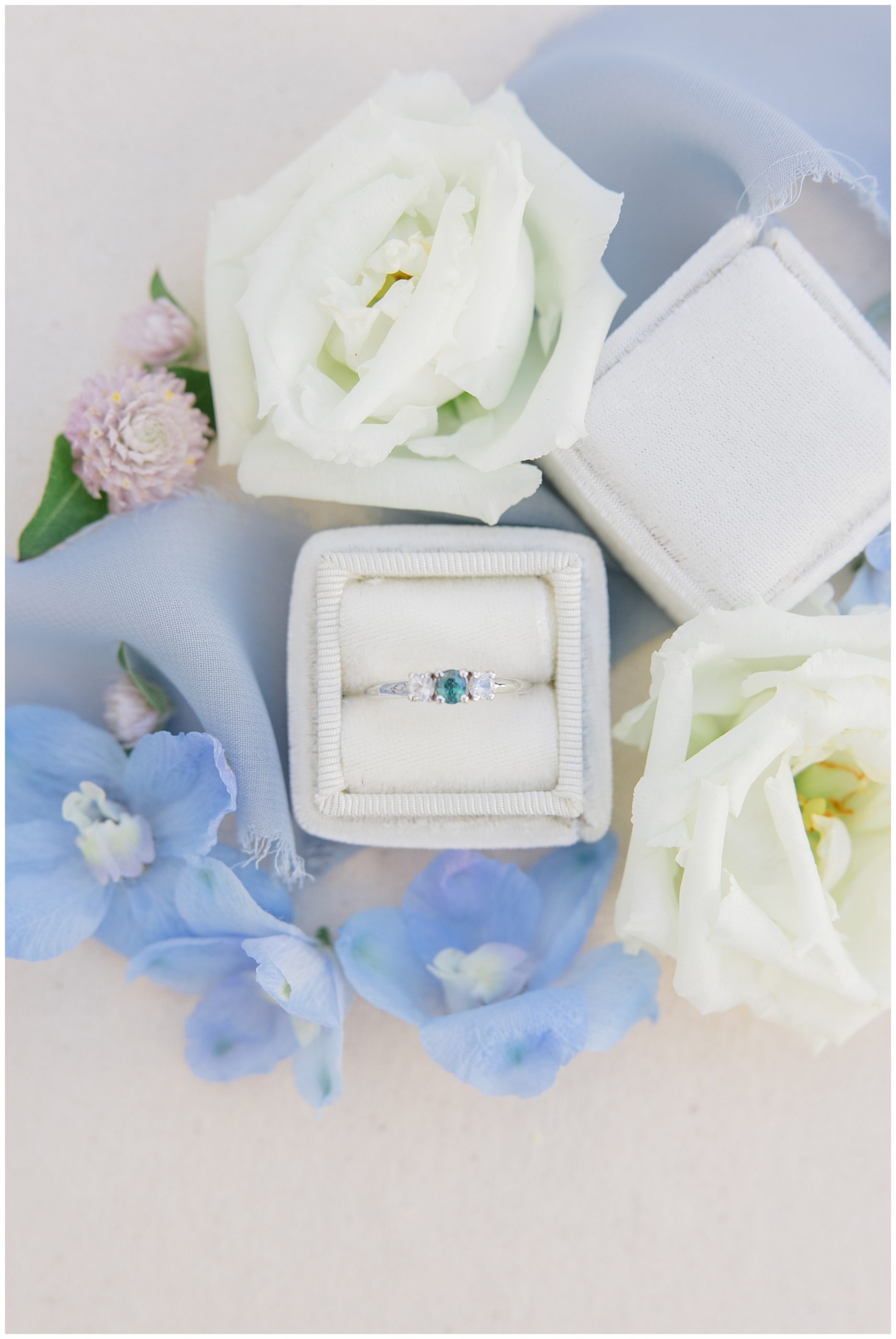 rings in ring box surrounded by wedding flowers