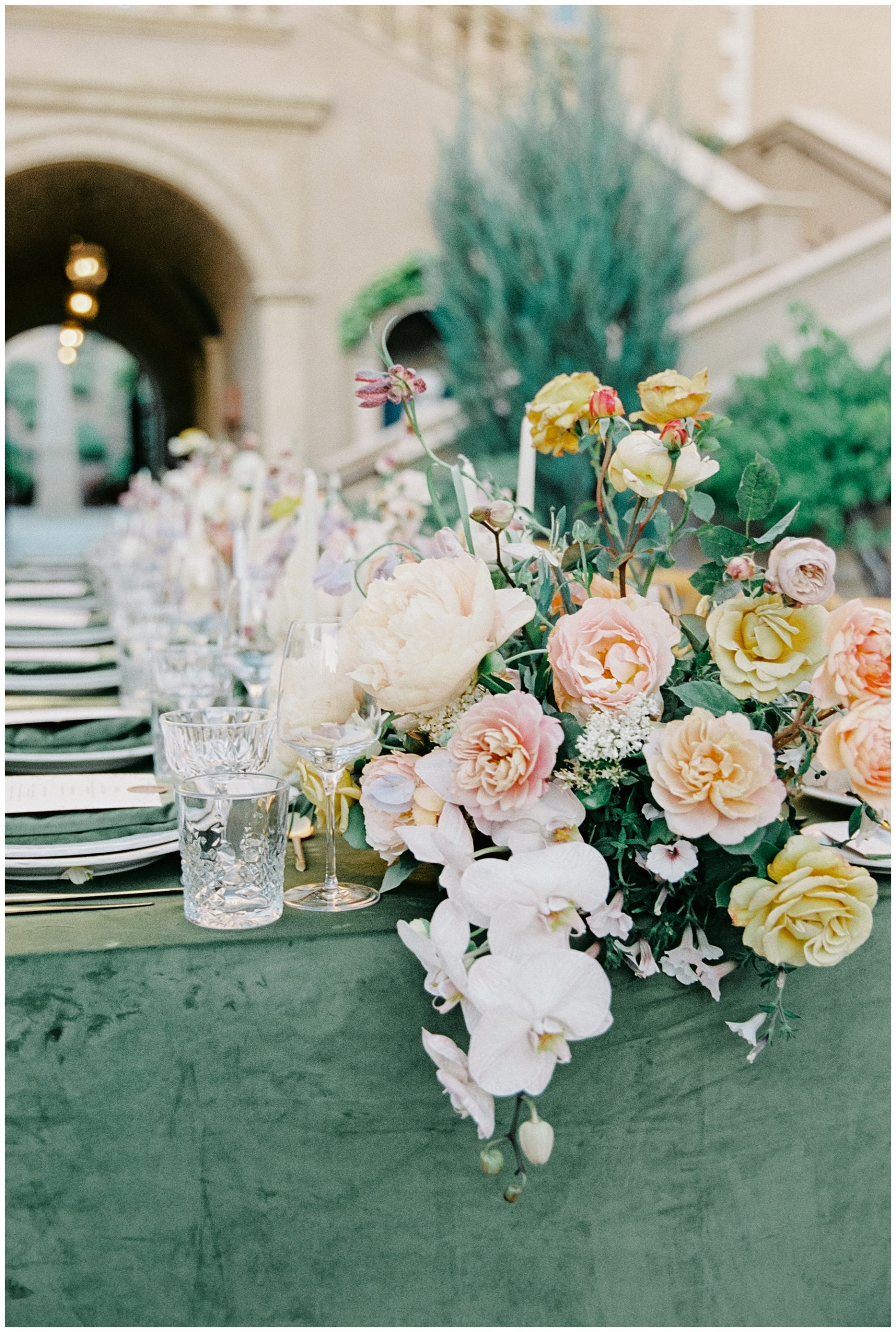 flower centerpieces on sage green tablecloth 