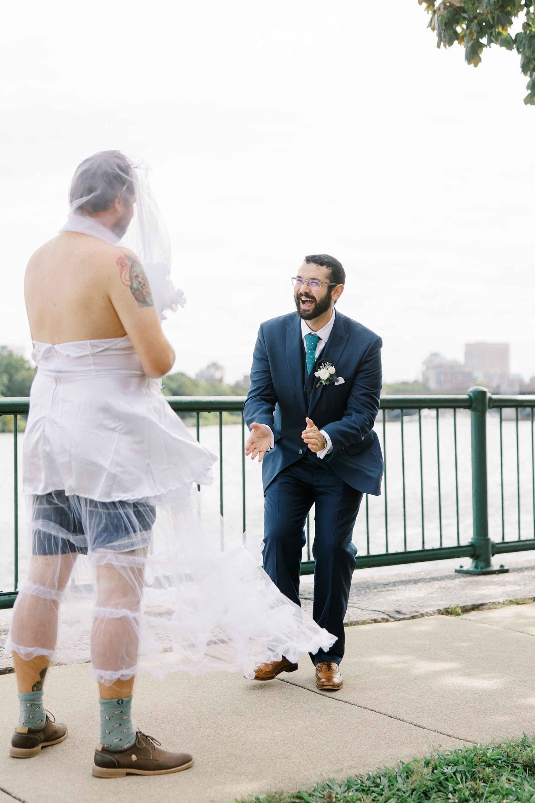 groom laughing at seeing his friend during faux first look