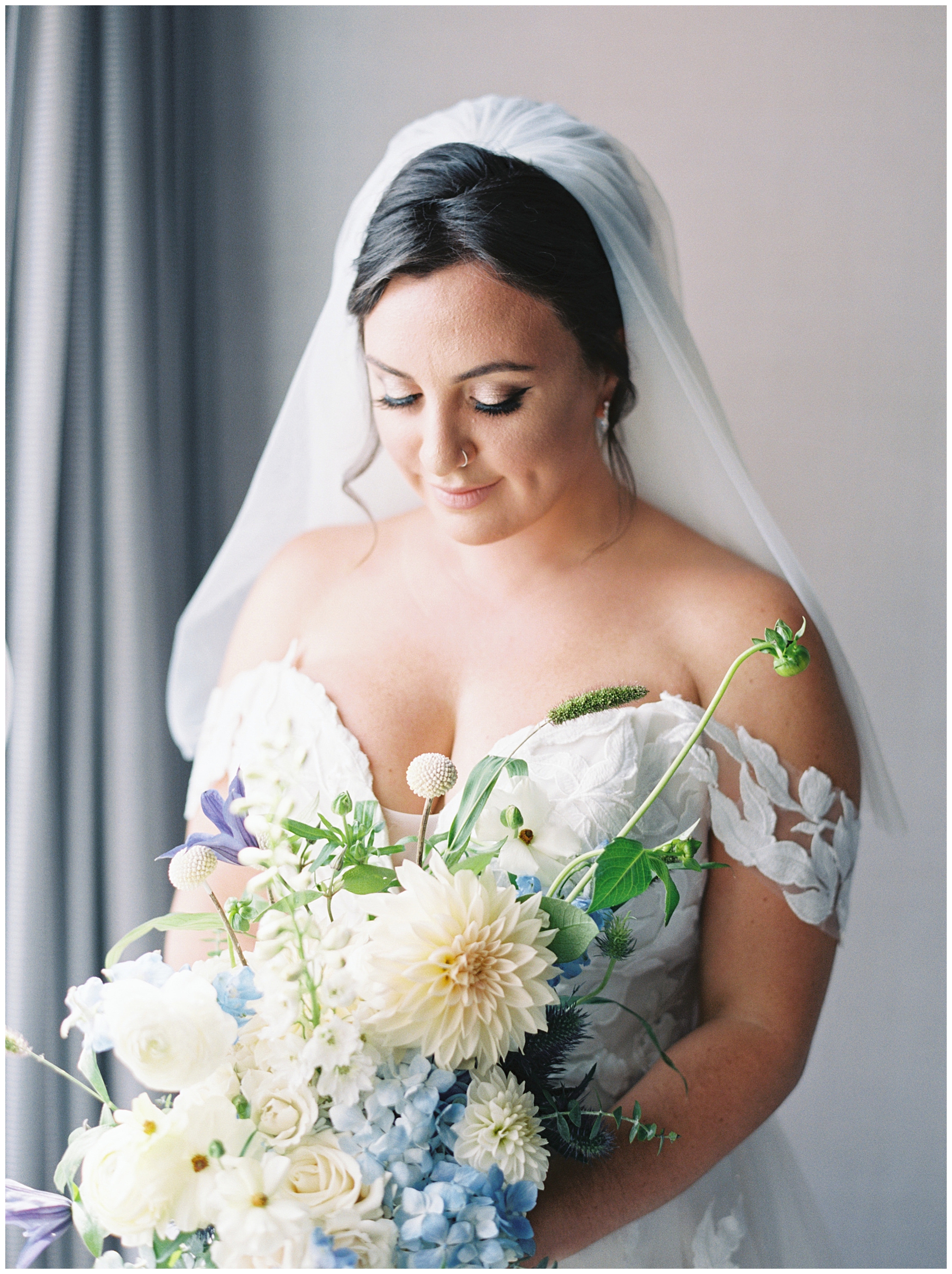 bride looks down at wedding bouquet