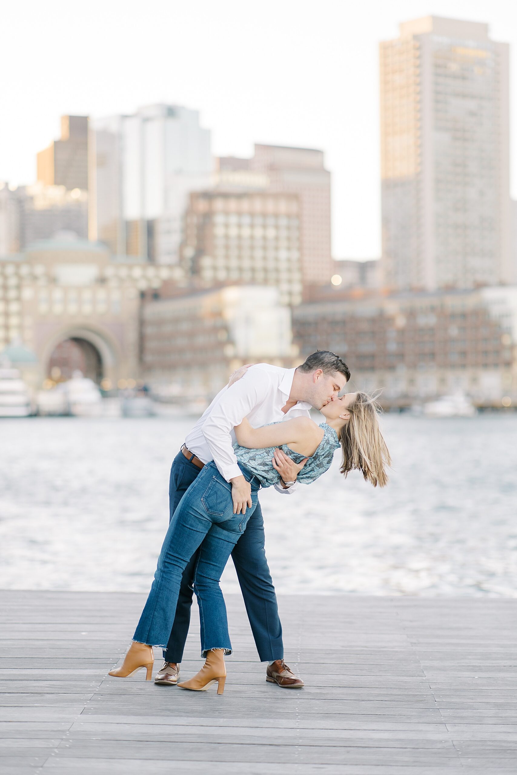 engaged couple kiss during engagement at Fan Pier Park