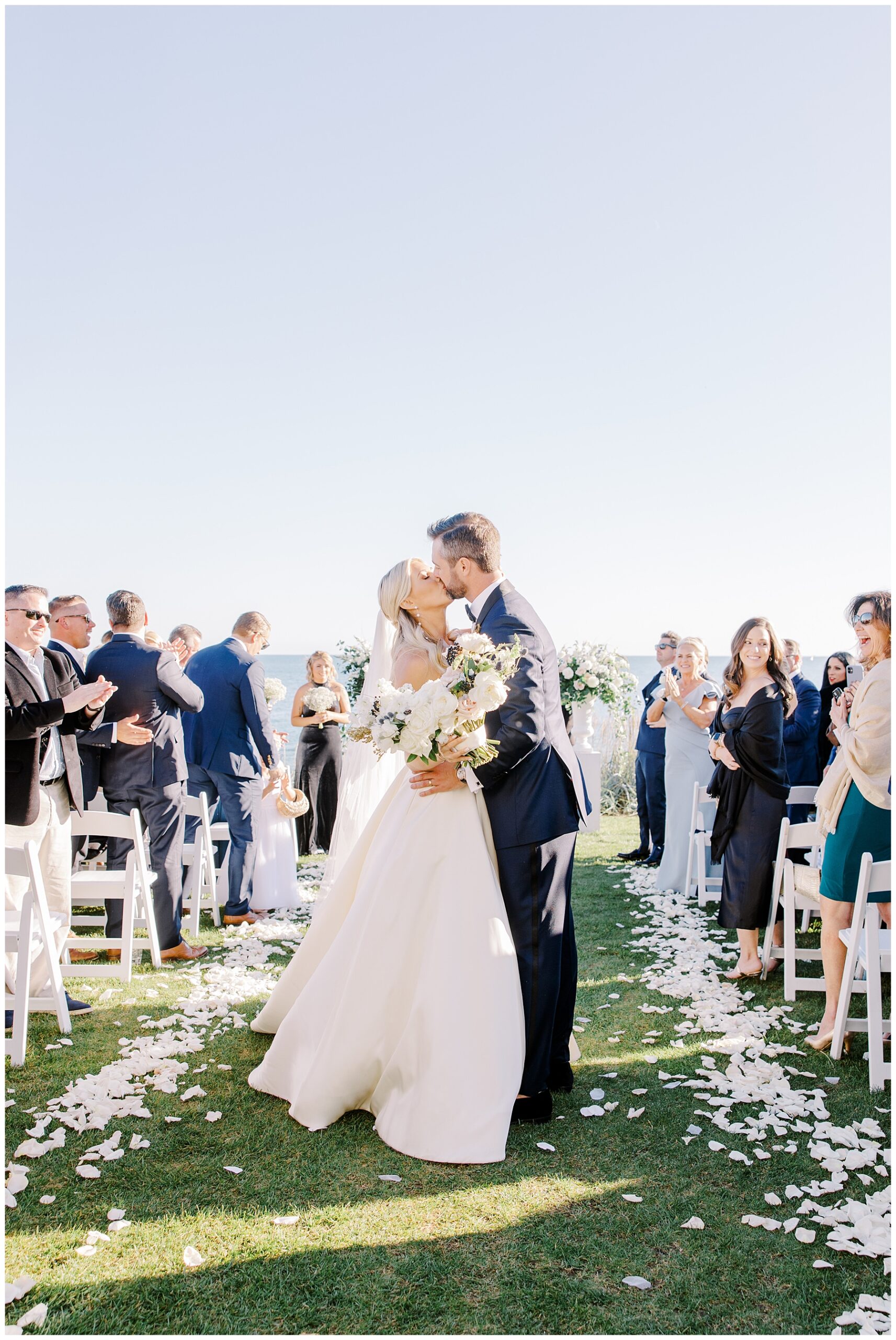 newlyweds kiss during timeless wedding ceremony at Pelham House Resort in Cape Cod 