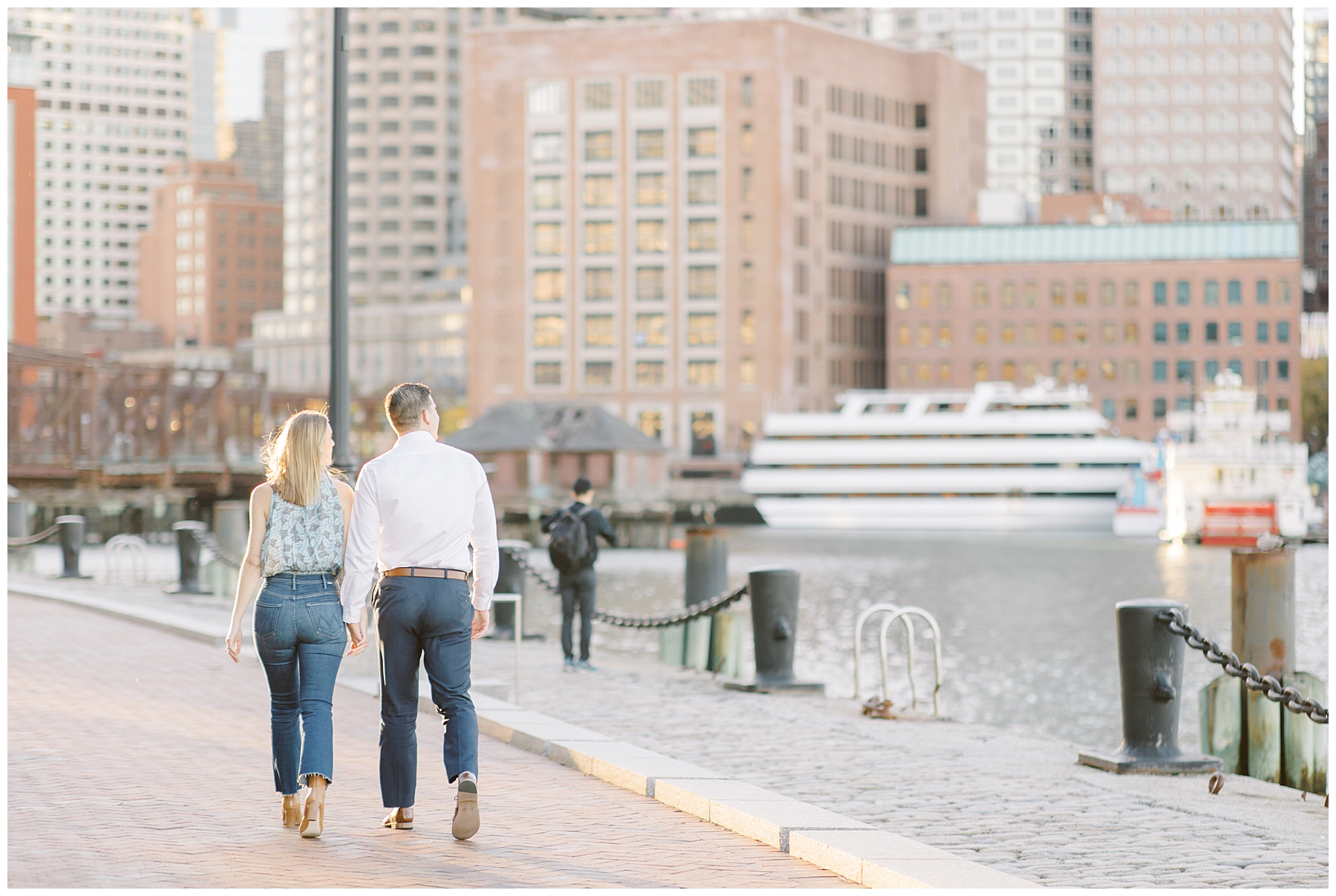couple walk along harbor at Fan Pier Park