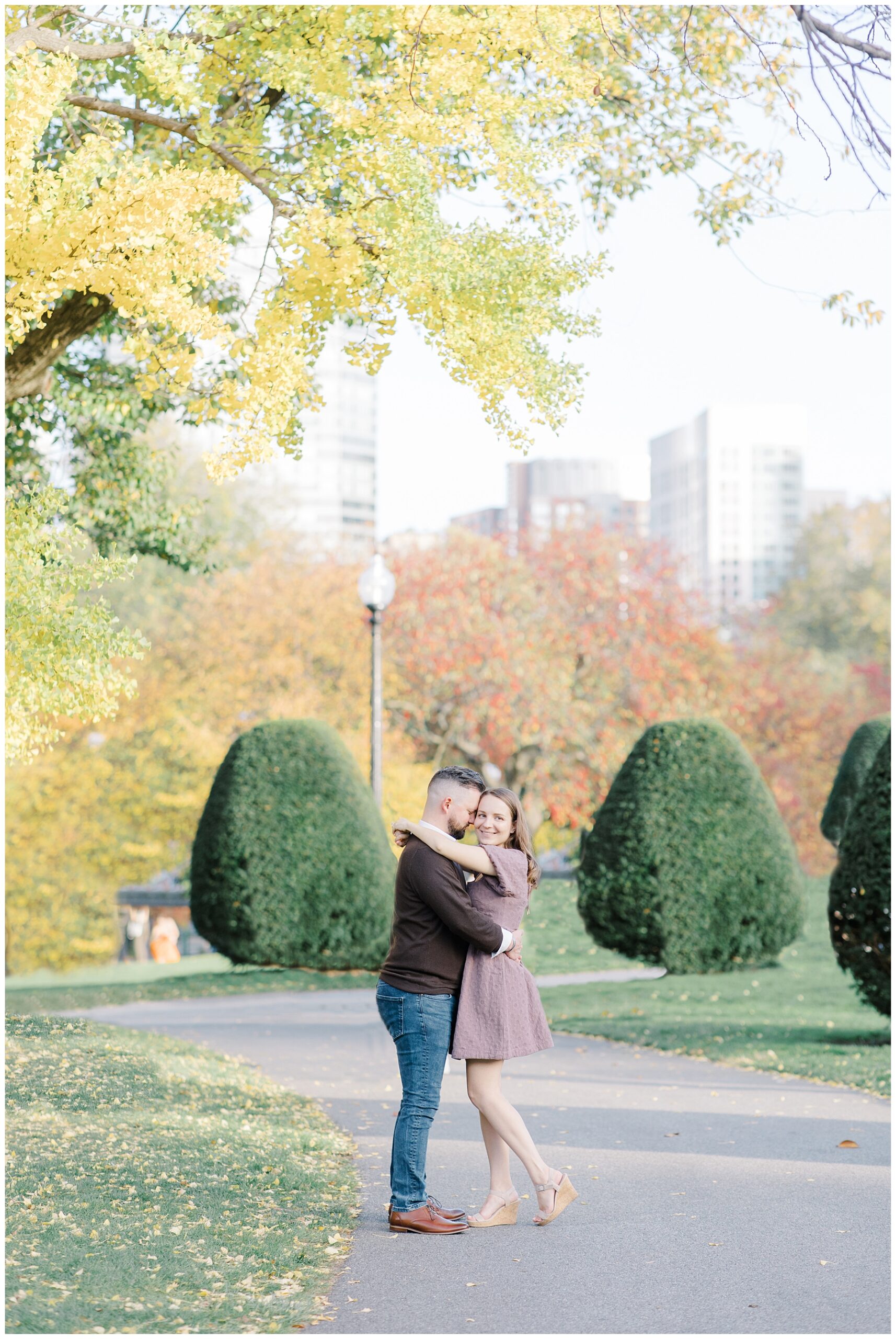 couple hug during fall engagement photos in Boston