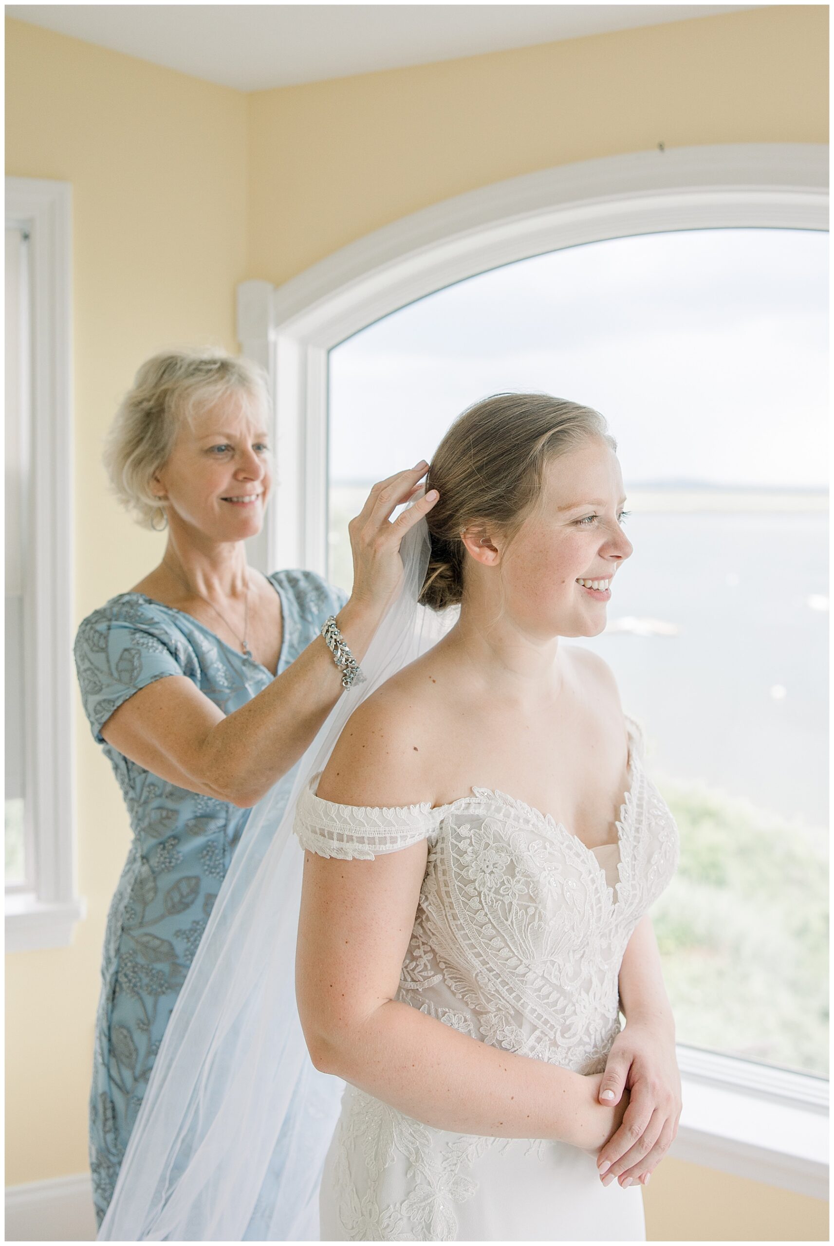 mom helping daughter with wedding veil