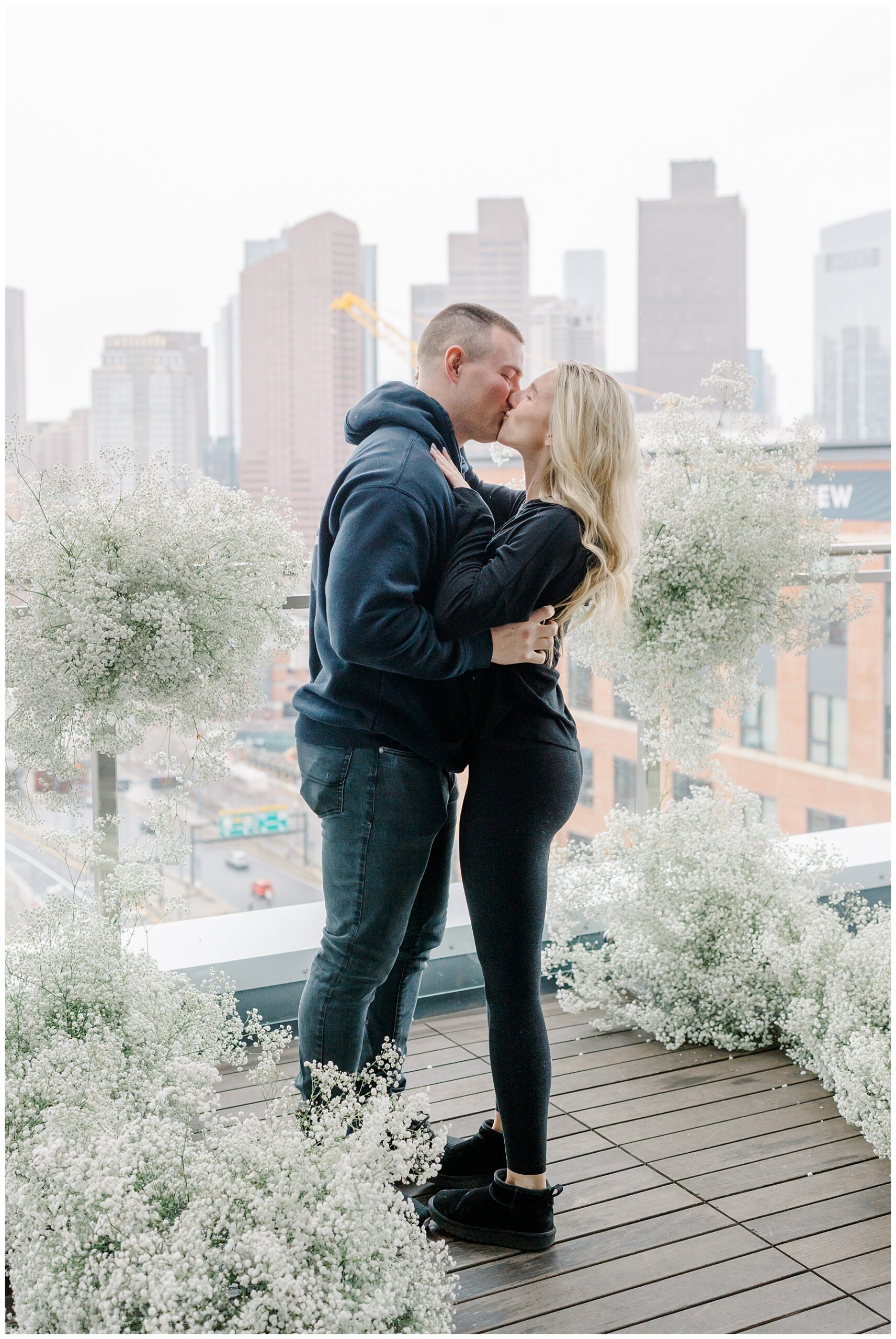 couple kiss after proposal on Boston balcony