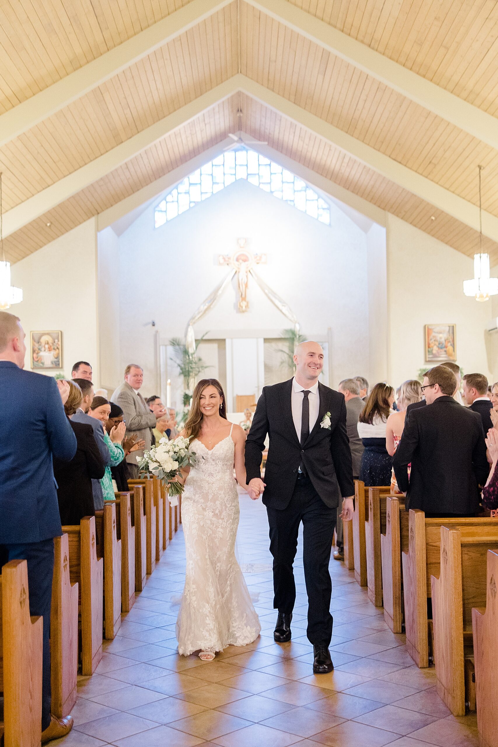 newlyweds walk out of church holding hands 