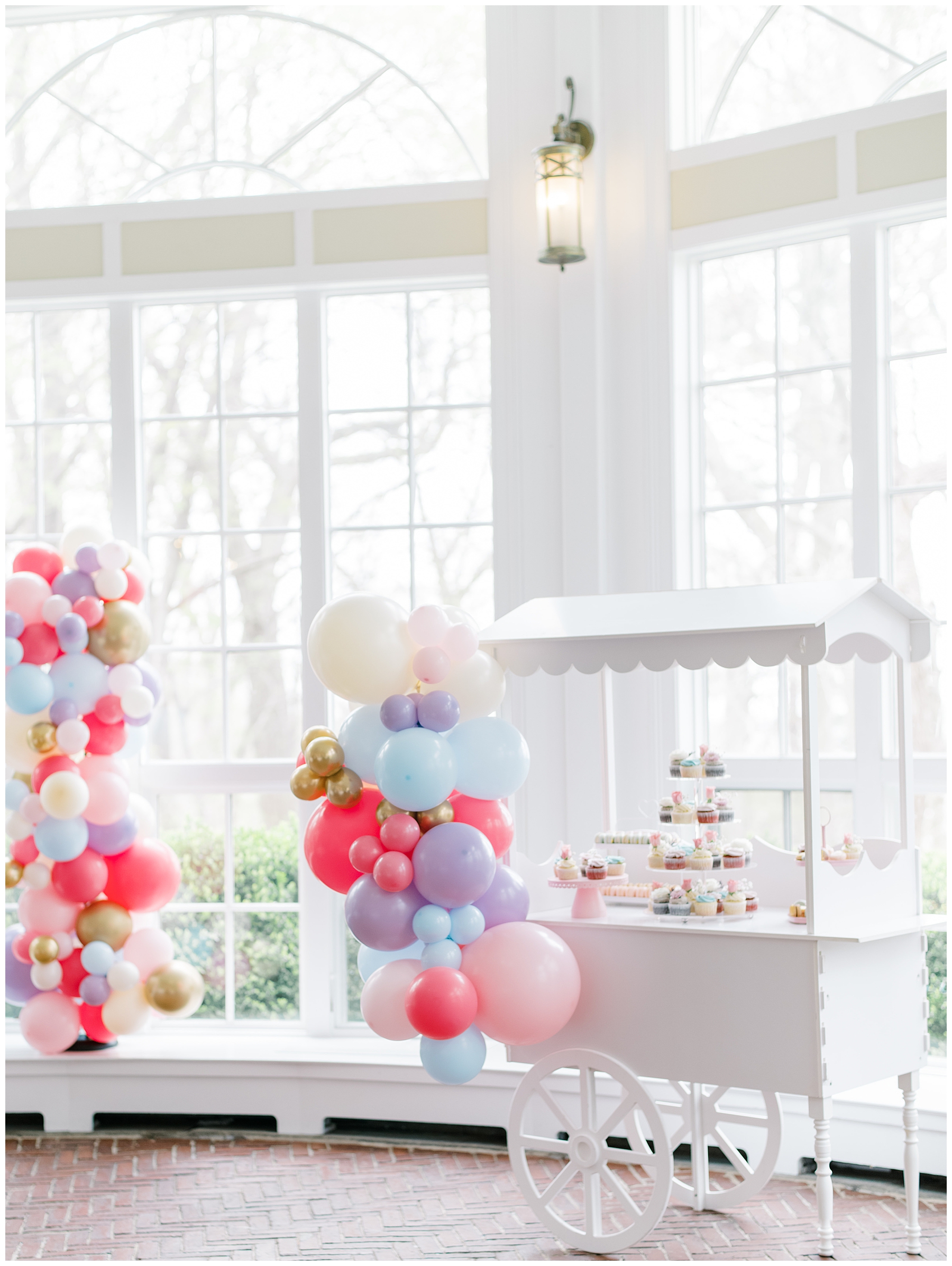 cupcake cart with decorated with colorful balloons