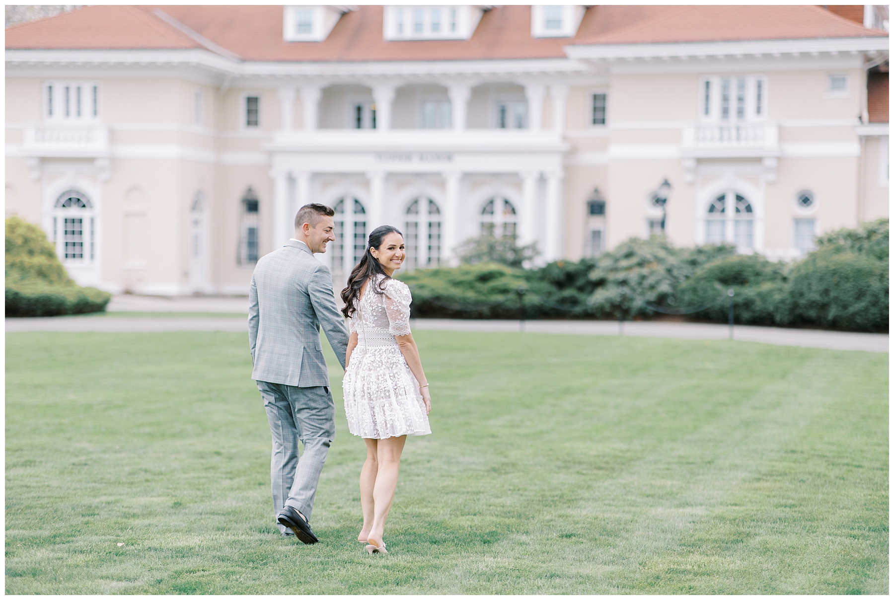 engaged couple walking across lawn of Tupper Manor in Beverly MA