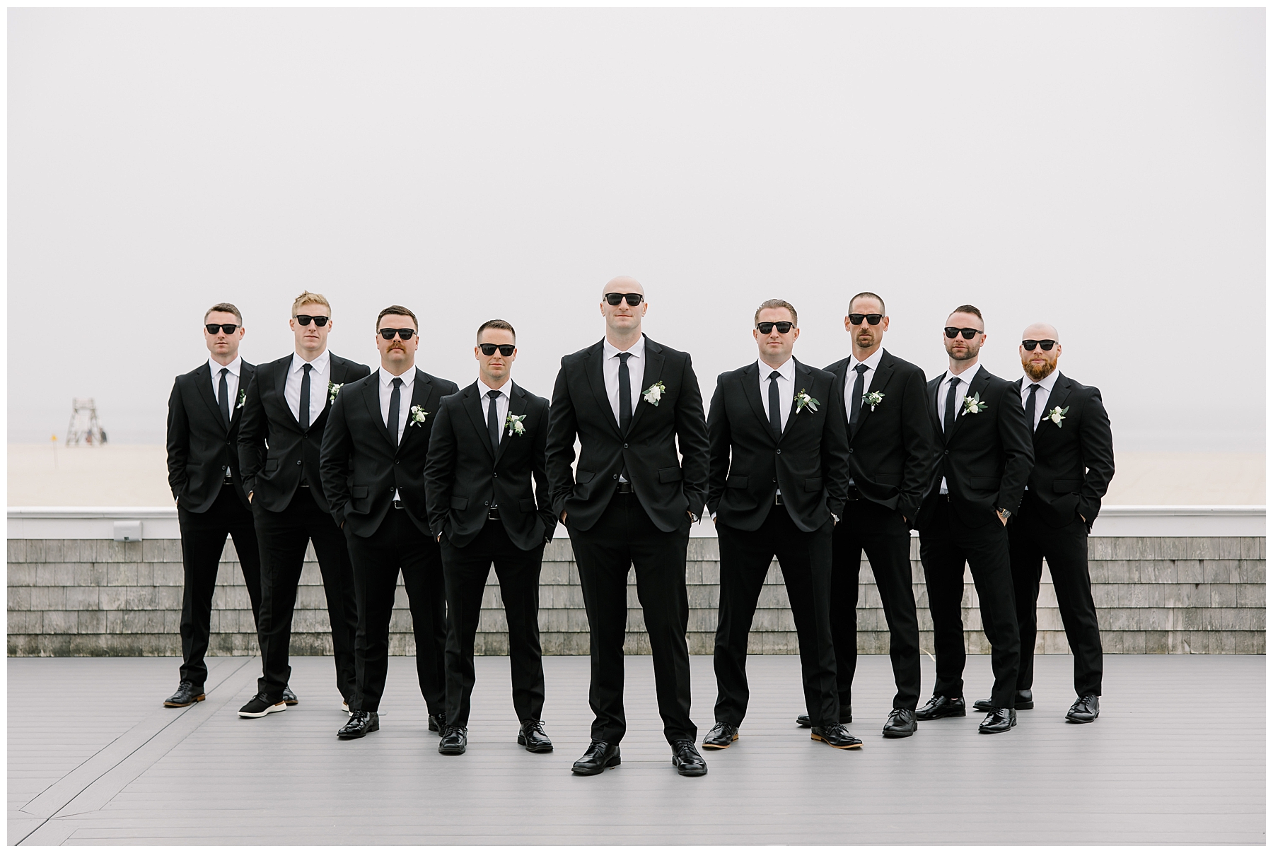 groomsmen with groom wearing black tuxes and sunglasses