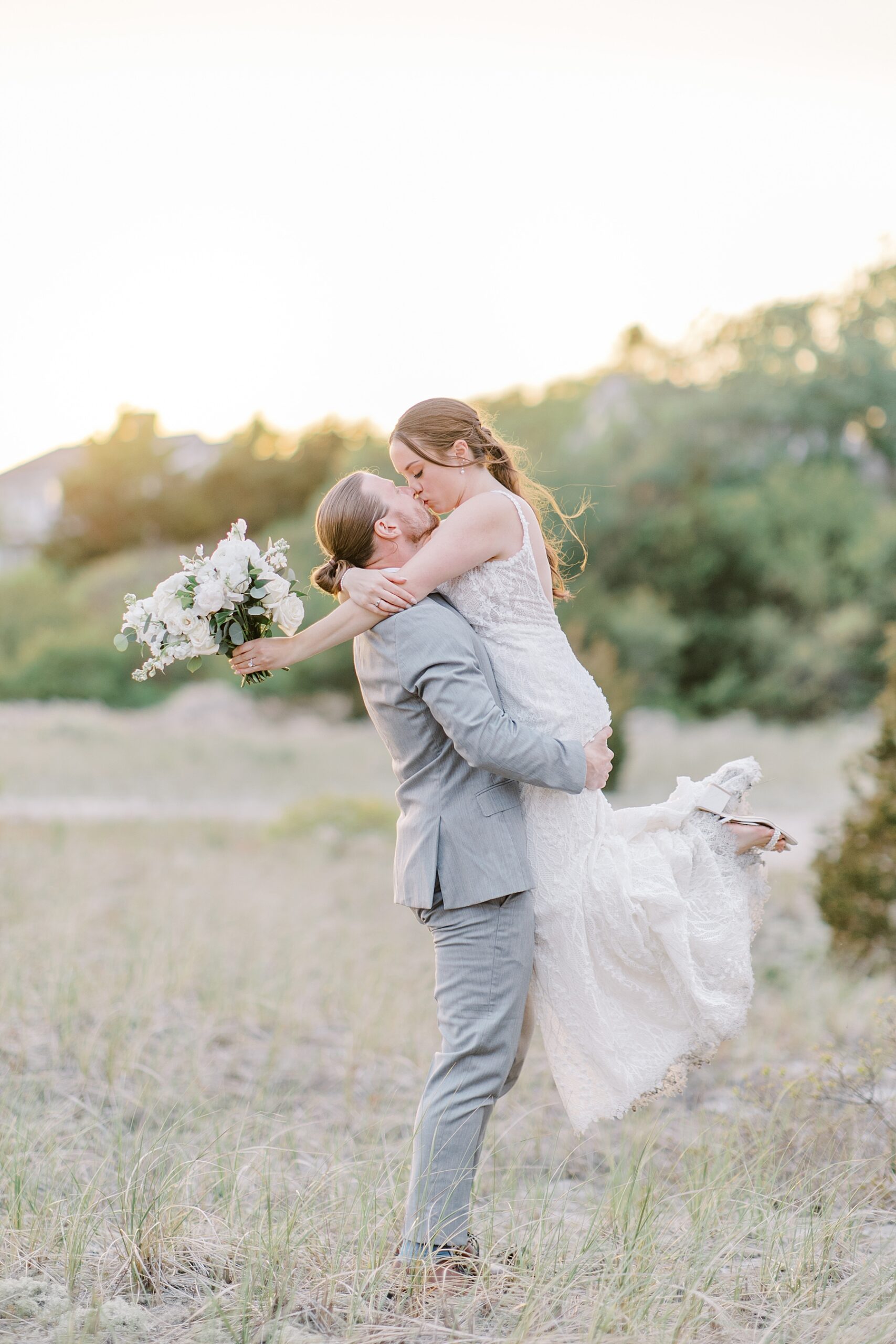 groom kisses and lifts his bride 
