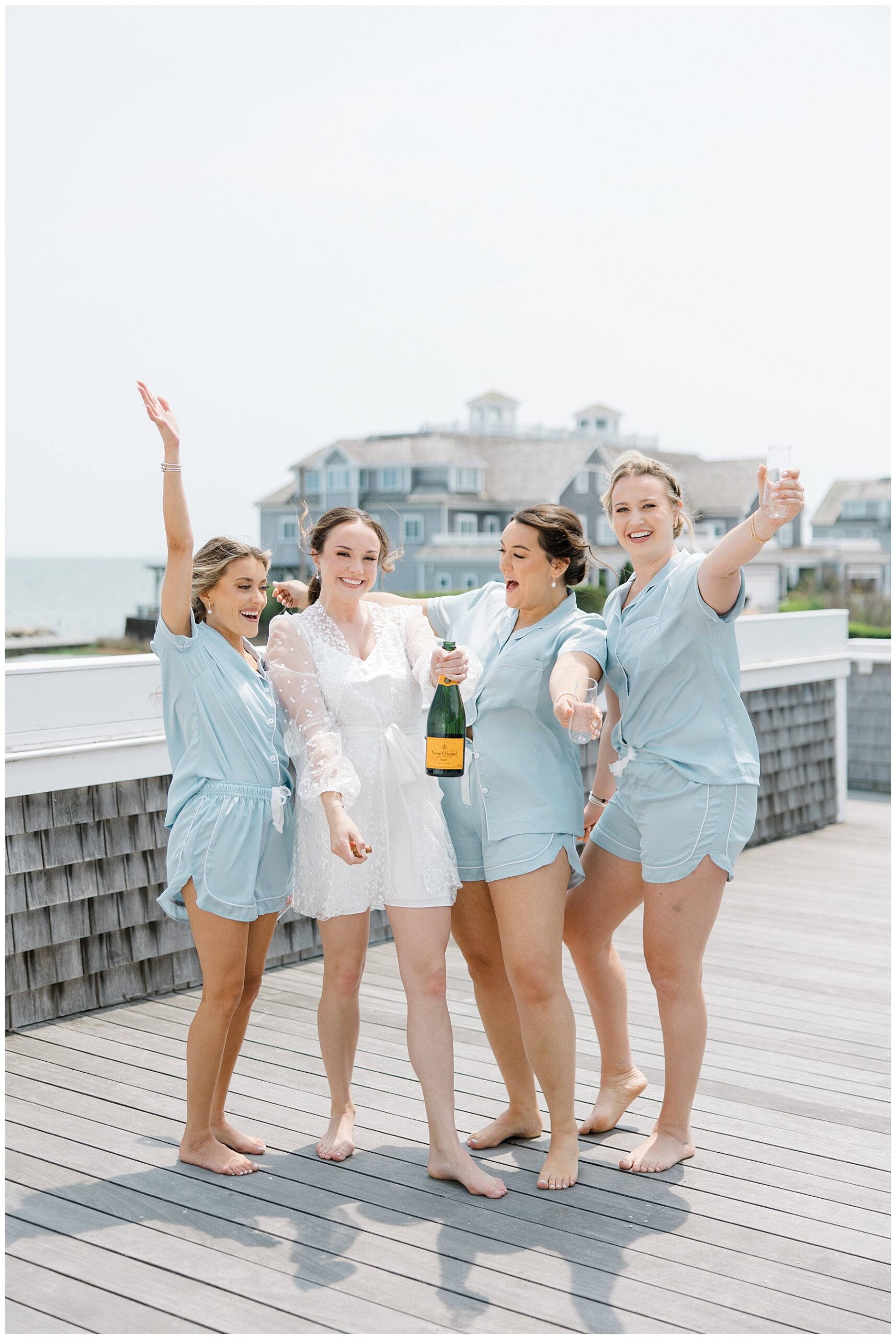 bride and bridesmaids on balcony with champagne
