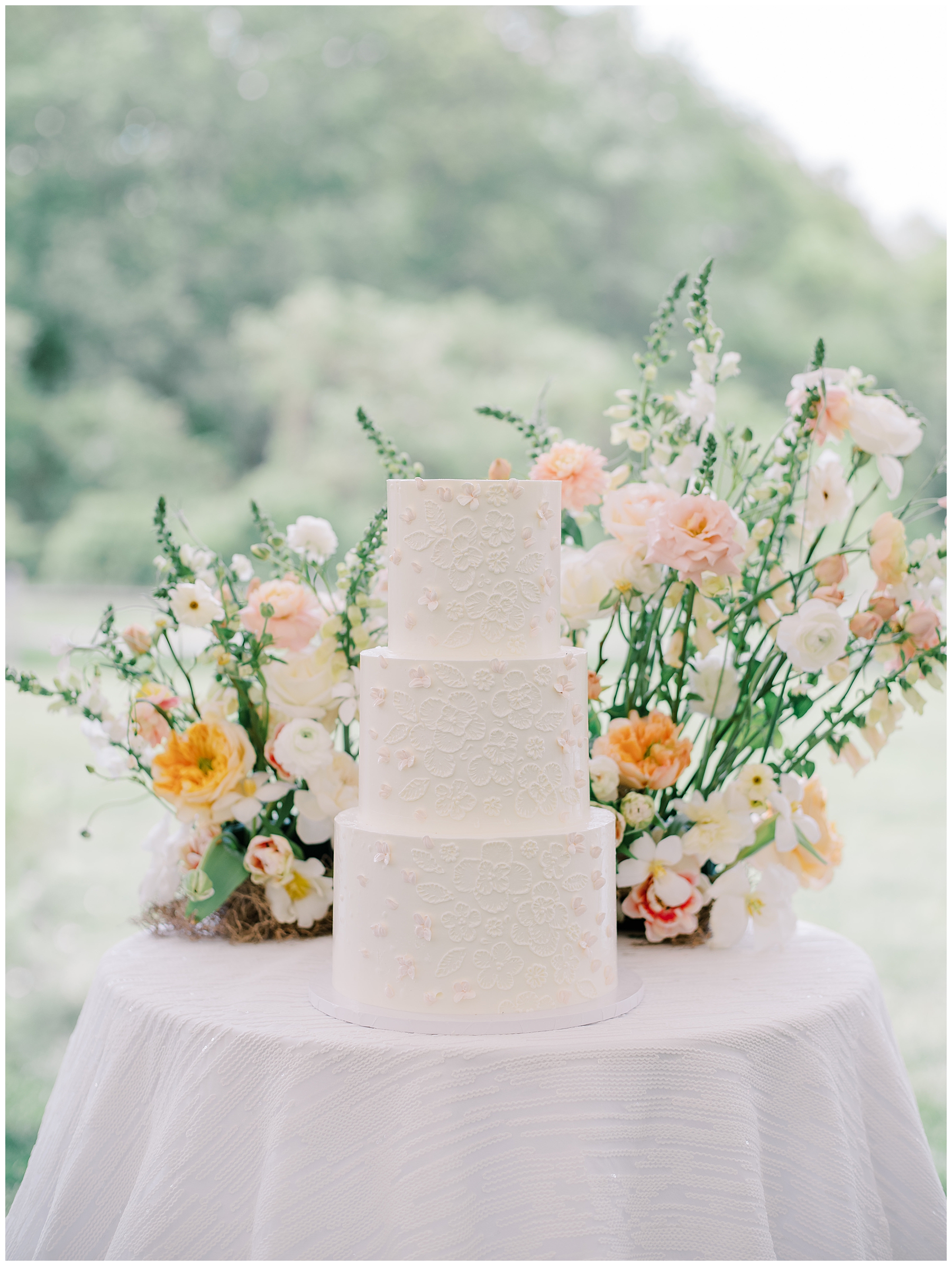 elegant three tiered wedding cake with spring floral arrangement 