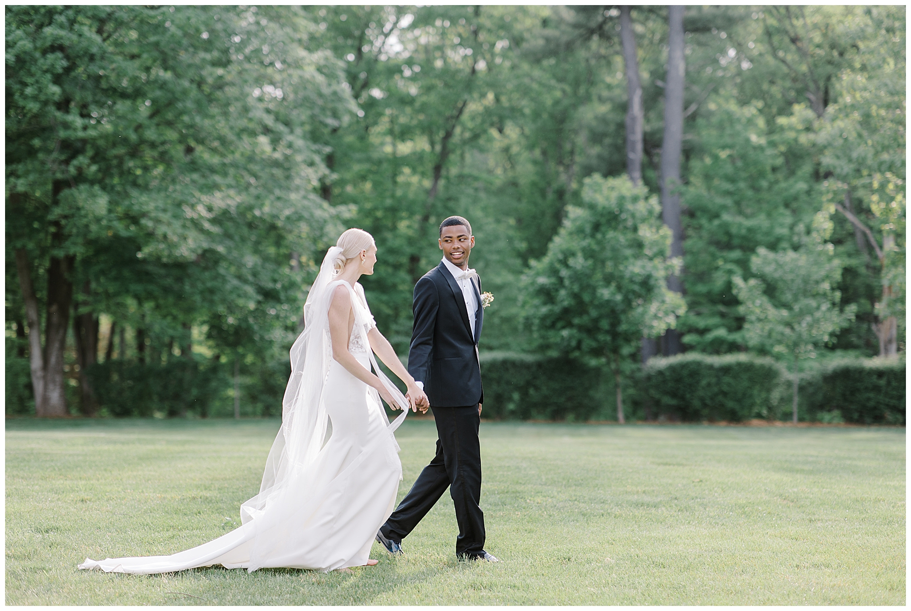 newlyweds walk across the lawn at Smith Farm Gardens