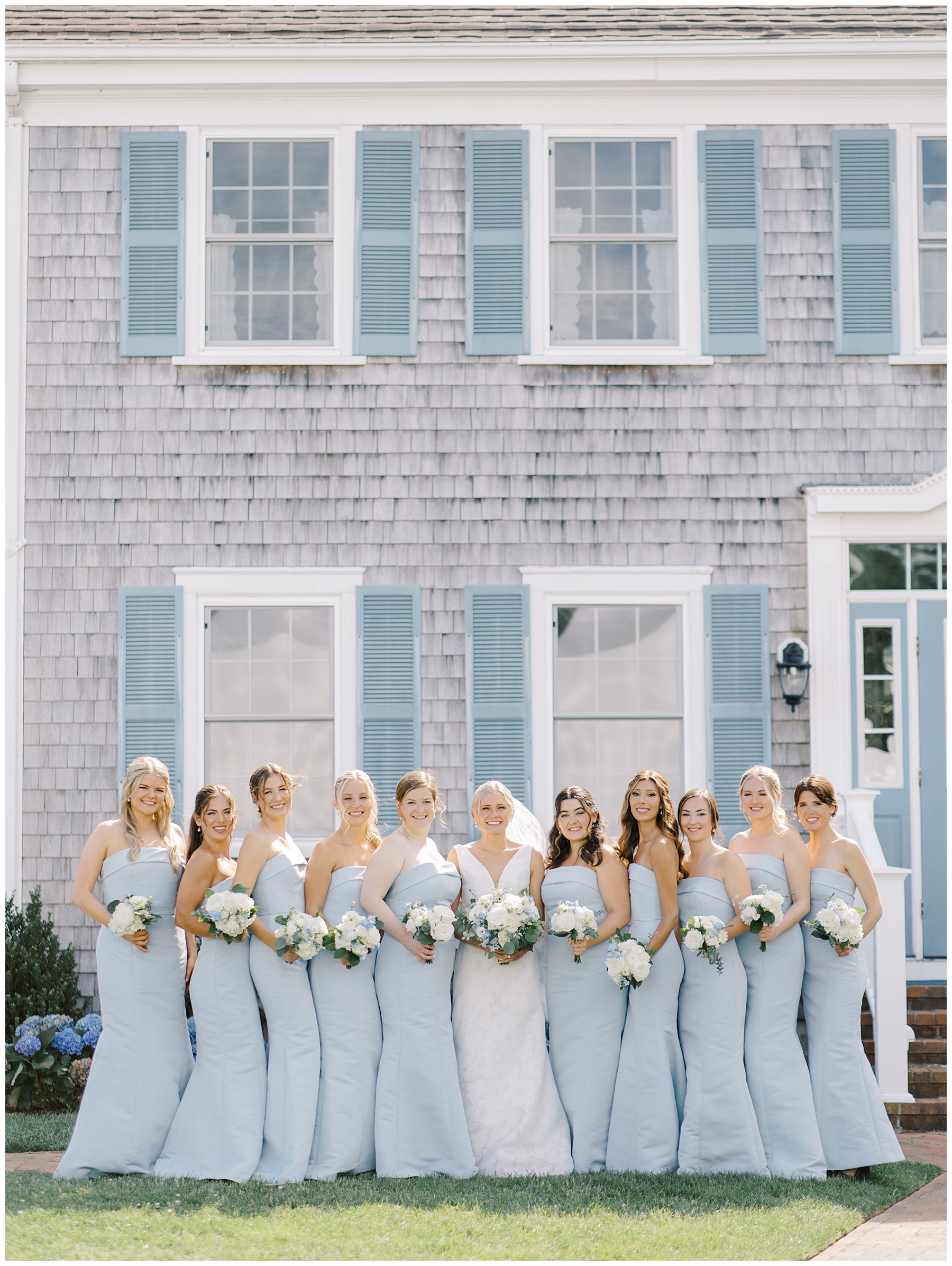 bride and bridesmaids in dusty blue dresses and elegant white wedding bouquets