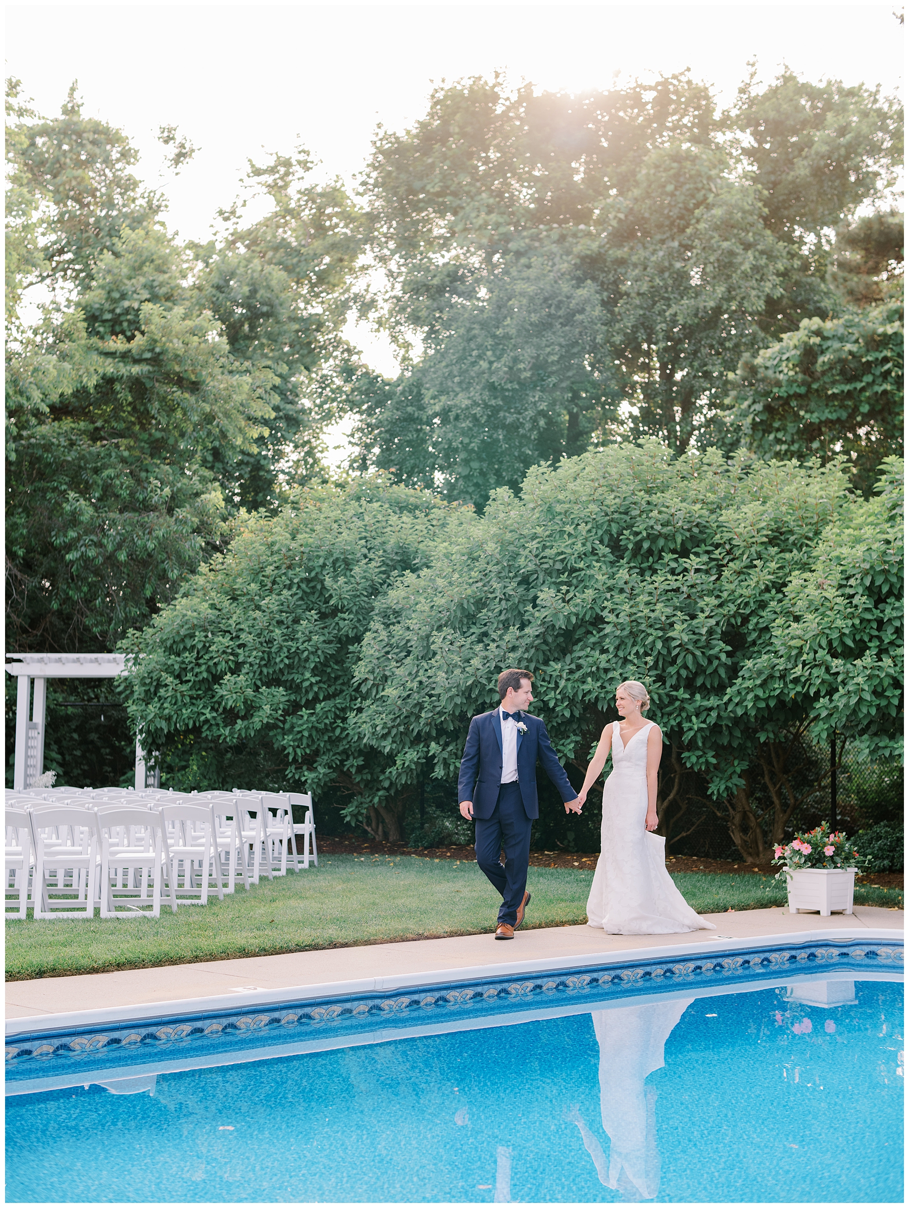 bride and groom walk together by the pool at The Dennis Inn