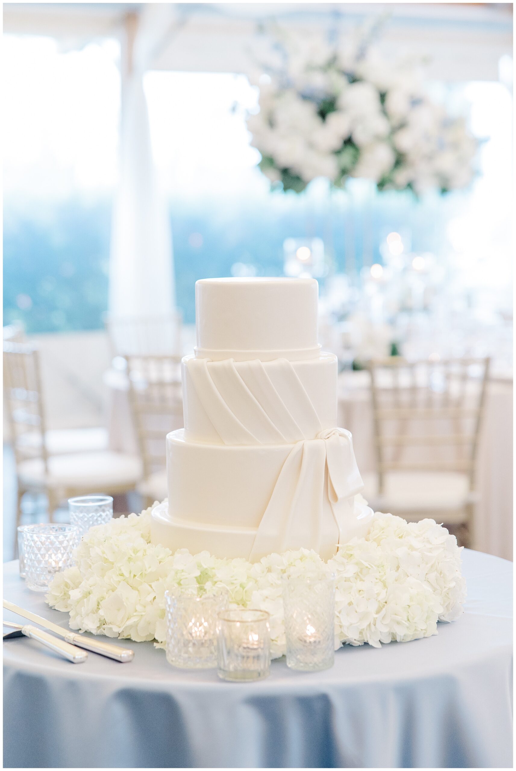 elegant and classic four tiered wedding cake surrounded by white flowers 