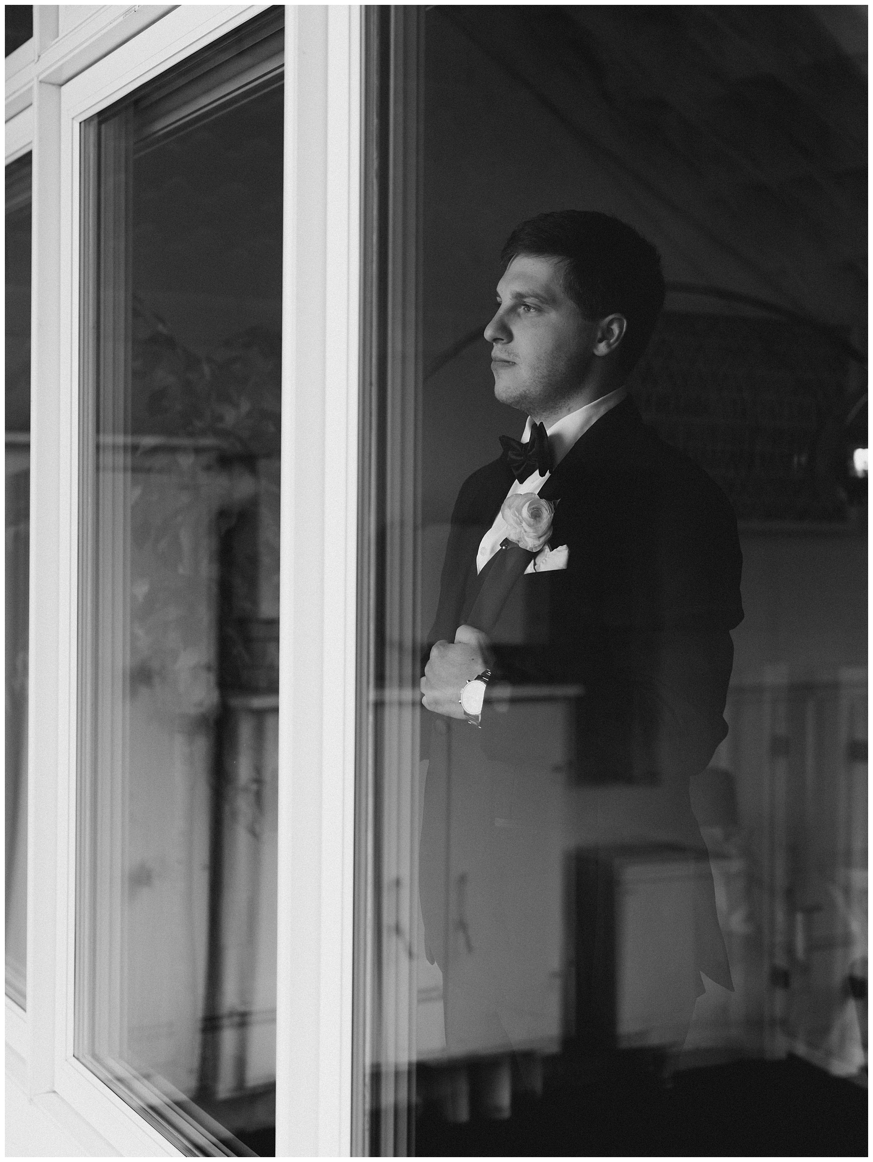 groom looks out window of ViewPoint Hotel