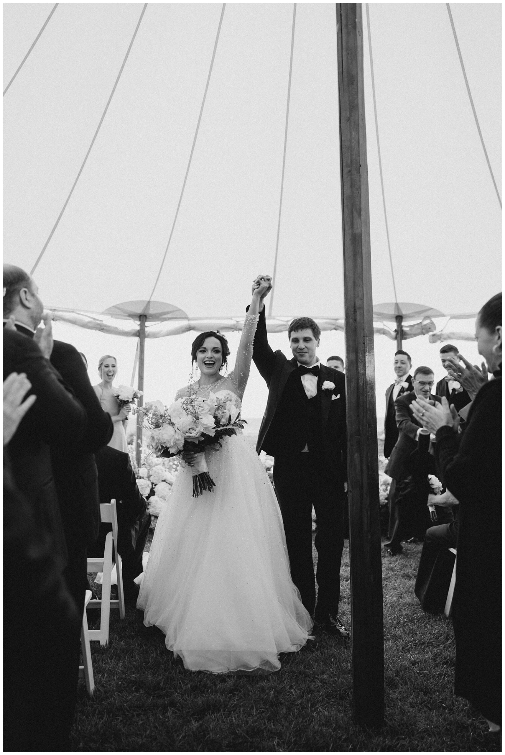 newlyweds exit outdoor tented wedding ceremony 