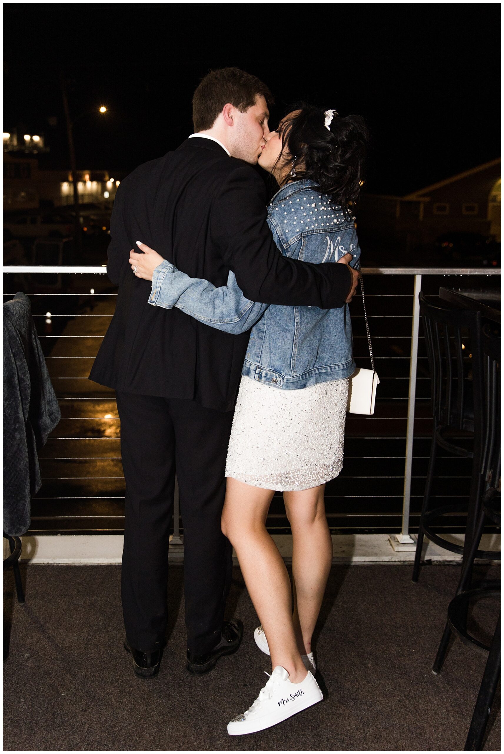 newlyweds kiss on deck after Elevated Coastal Maine Wedding at ViewPoint Hotel