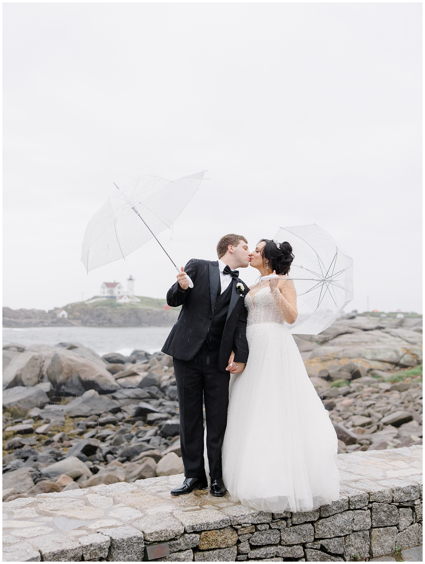couple kiss in the rain after wedding ceremony 