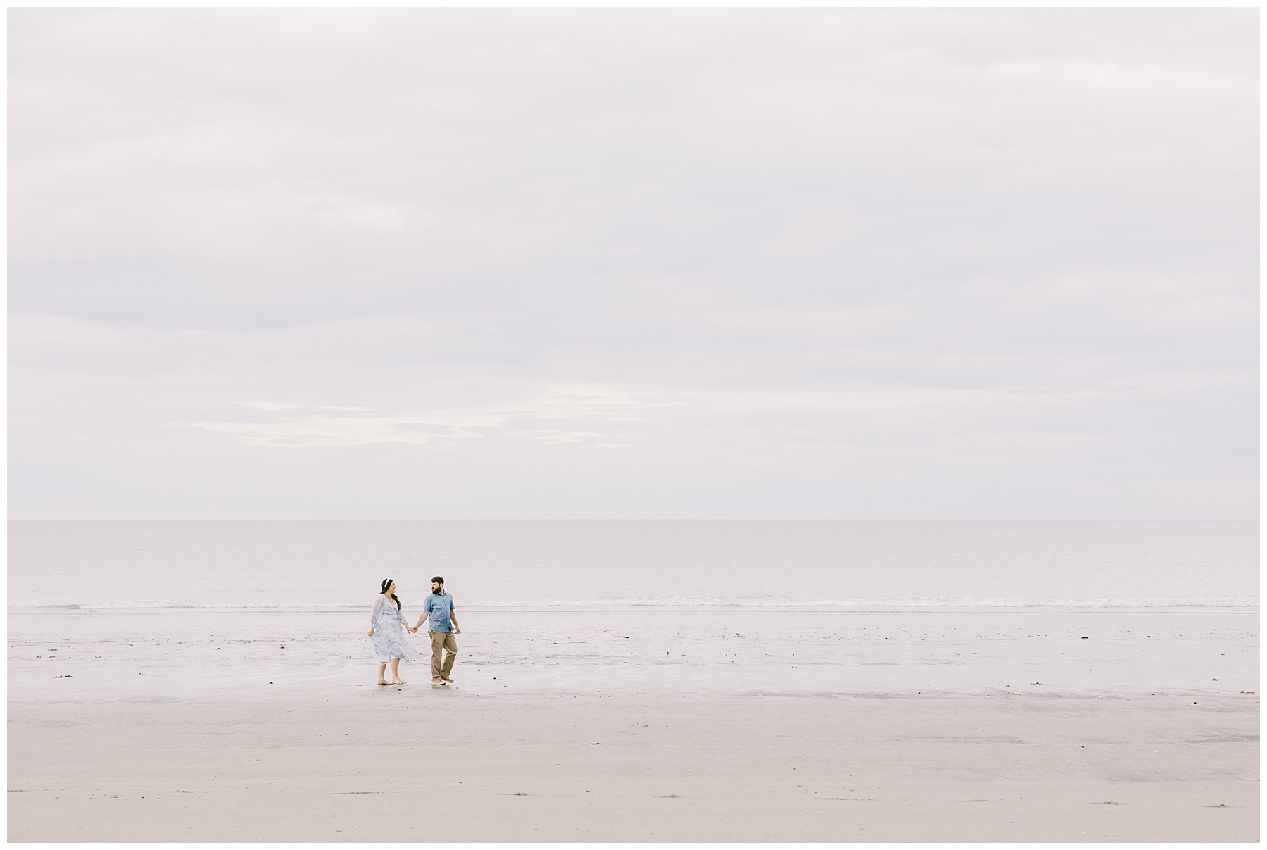 engaged couple hold hands on Nantasket Beach during Engagement session
