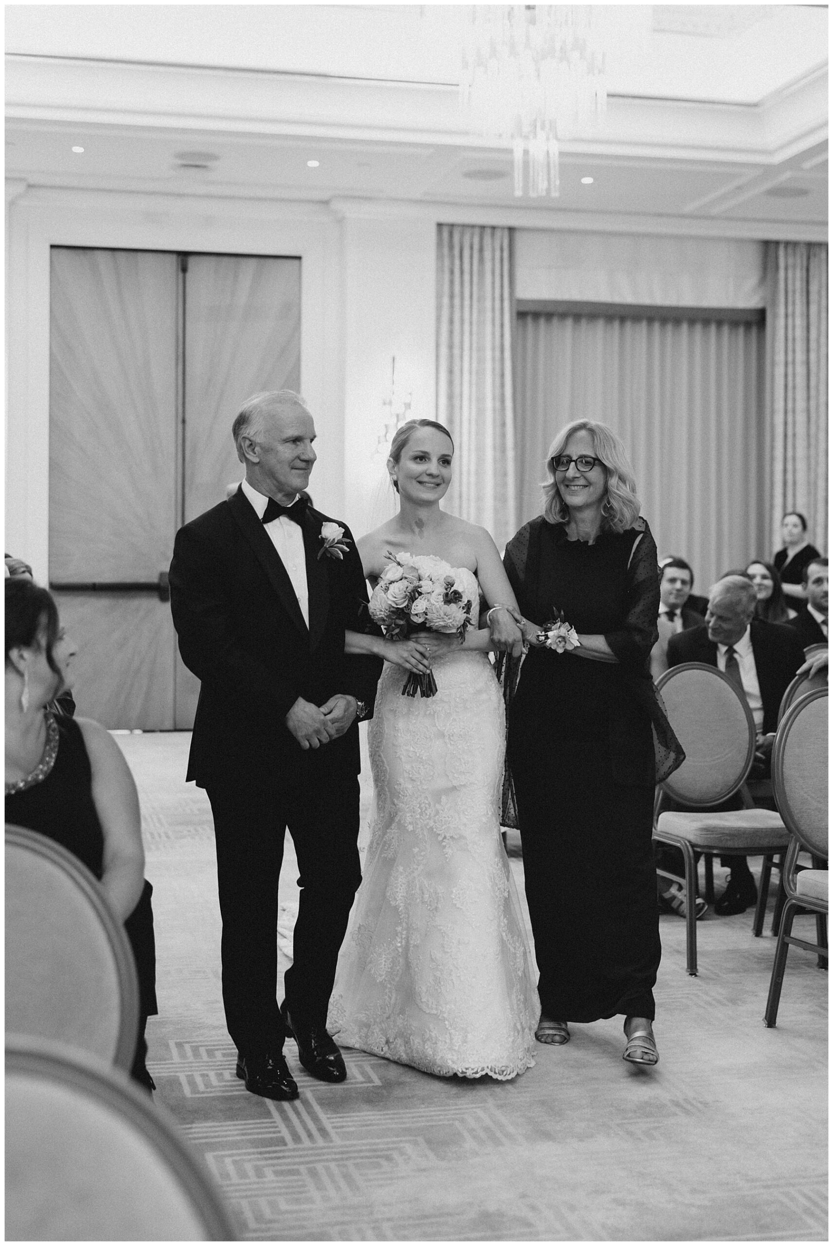 bride walking down the aisle with her parents 