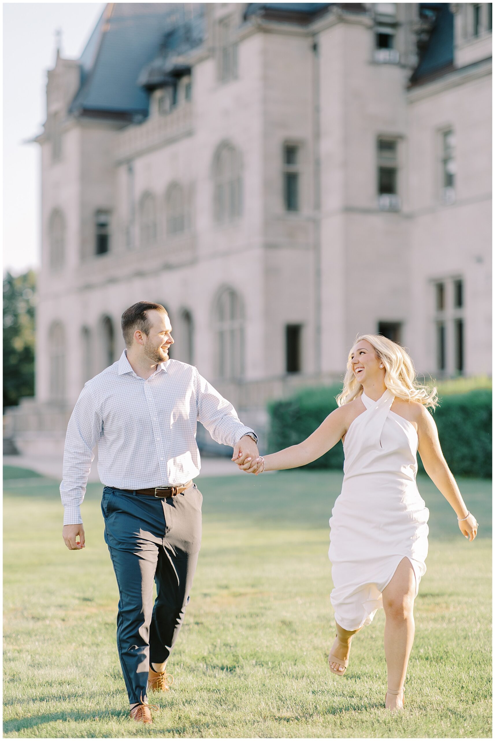 candid engagement portraits of couple running across grounds of Ochre Court  