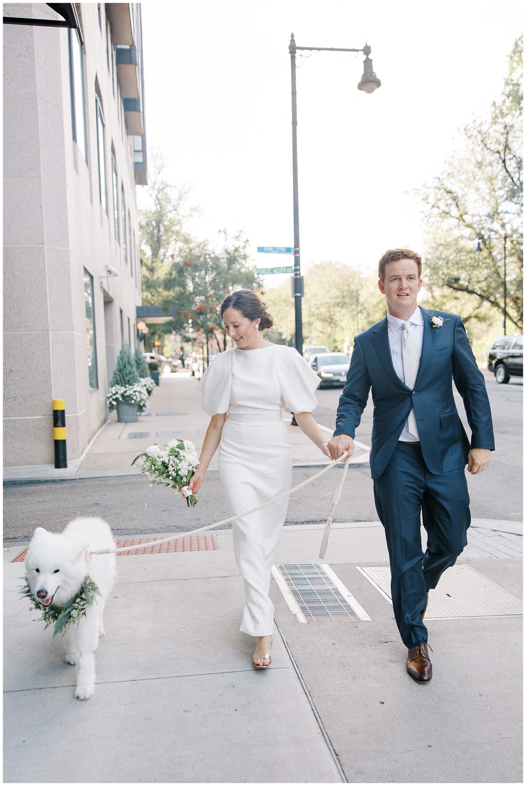 newlyweds walk their dog 