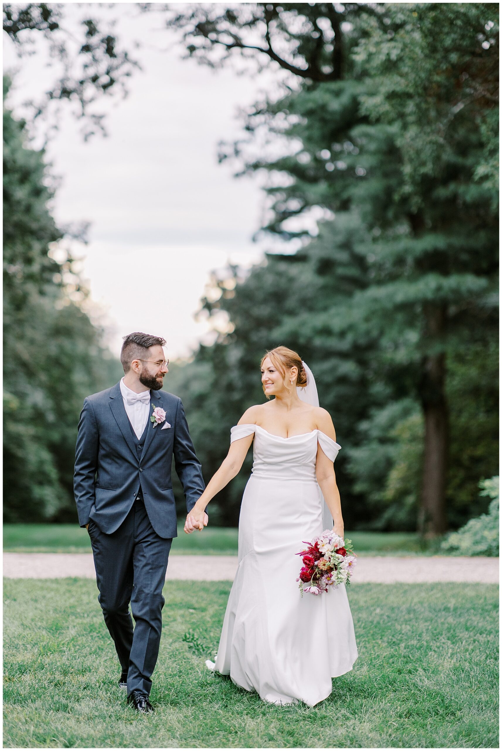 newlyweds hold hands and walk around the grounds