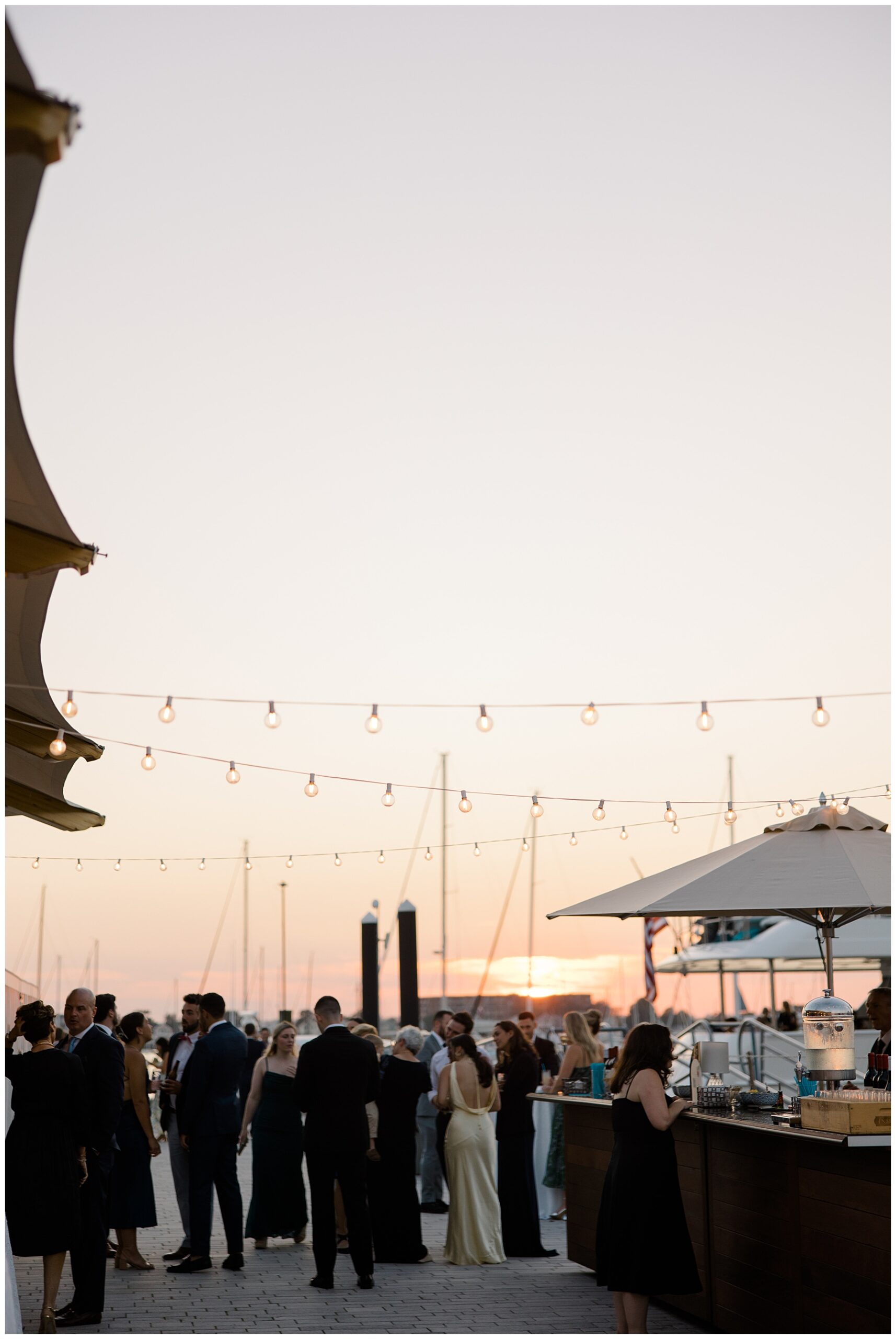 wedding guests on the dock at sunset from Luxurious Newport Wedding reception at The Bohlin 