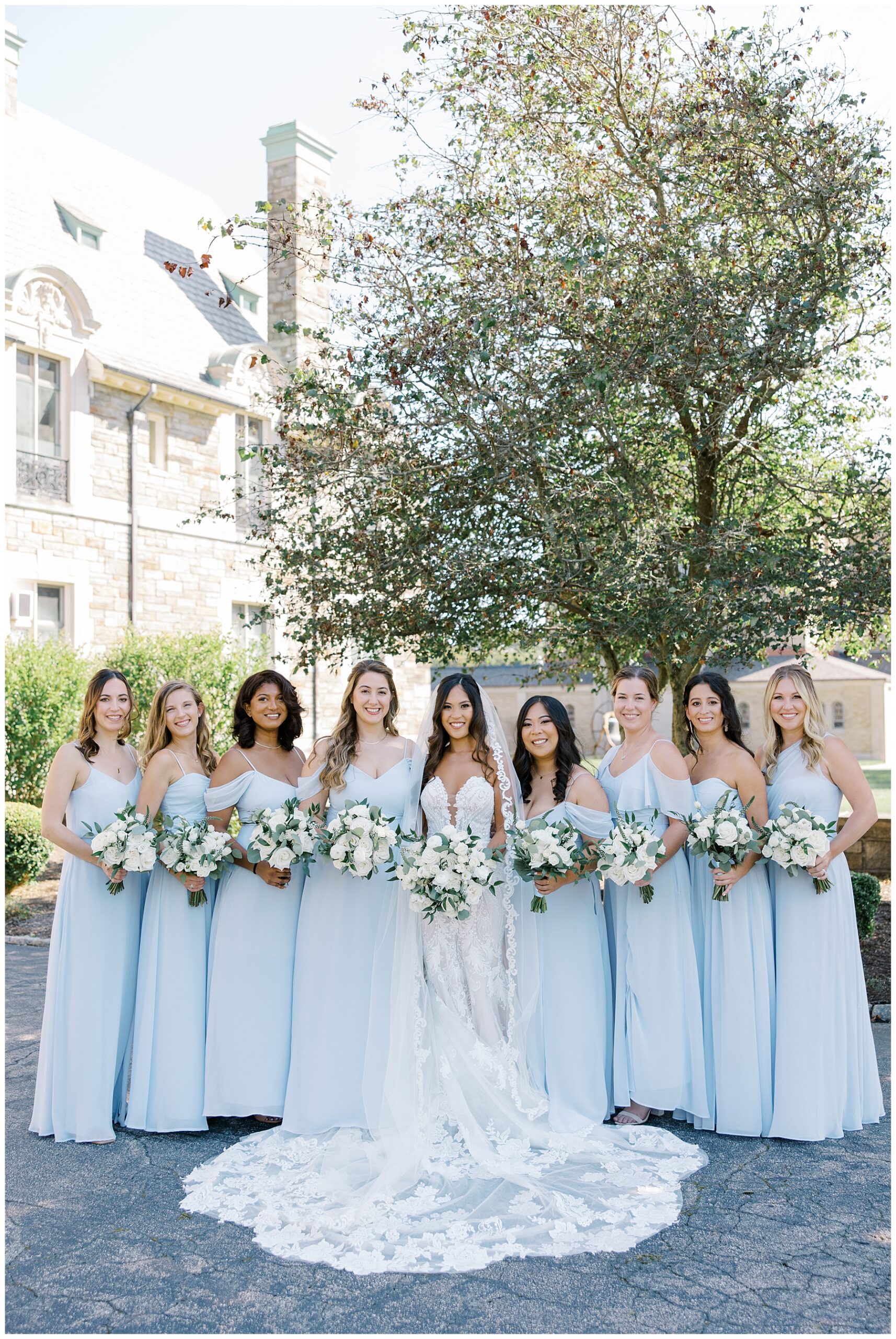 bride with bridesmaids in dusty blue wedding dresses