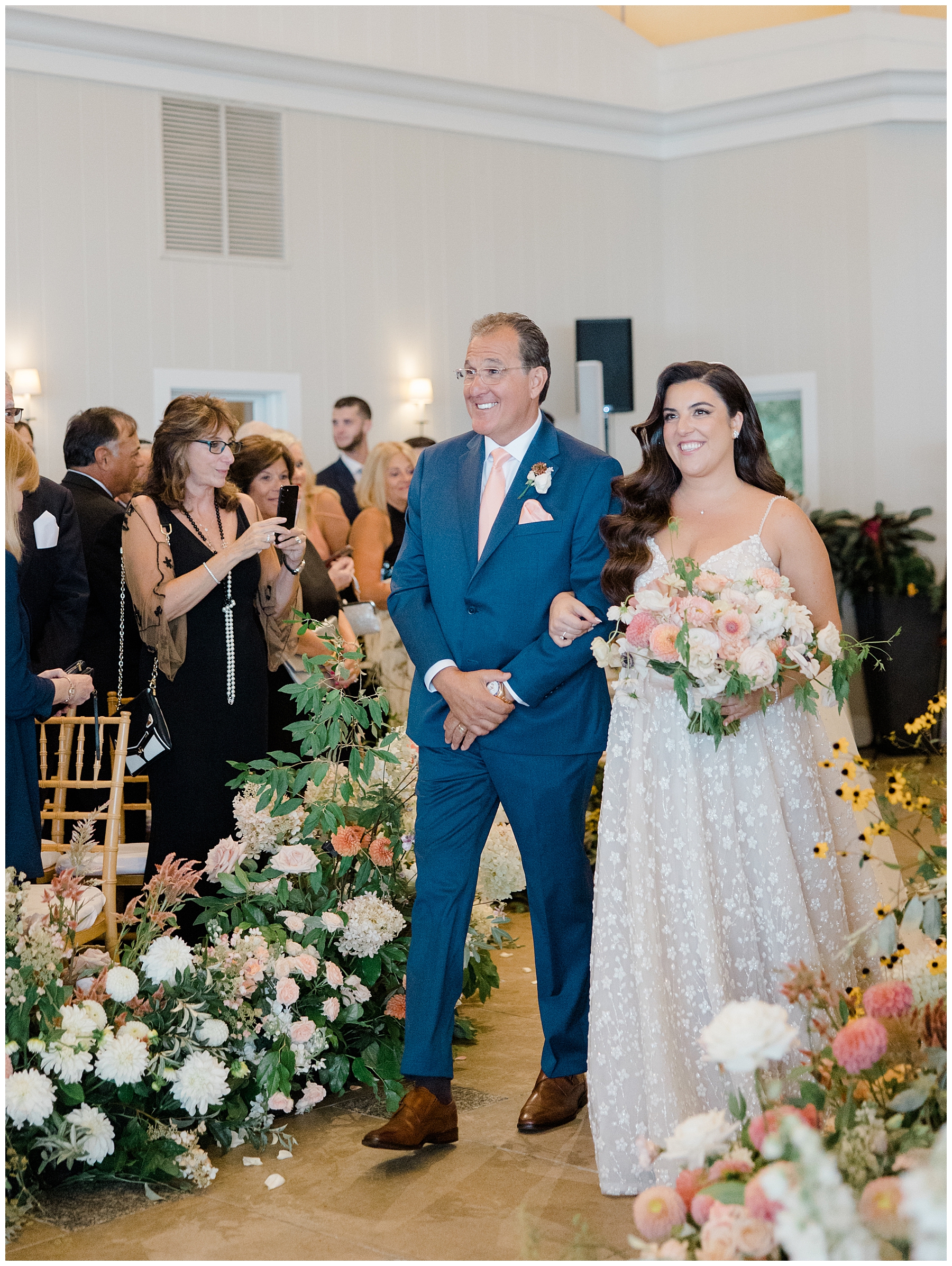 bride walks down aisle escorted by father 