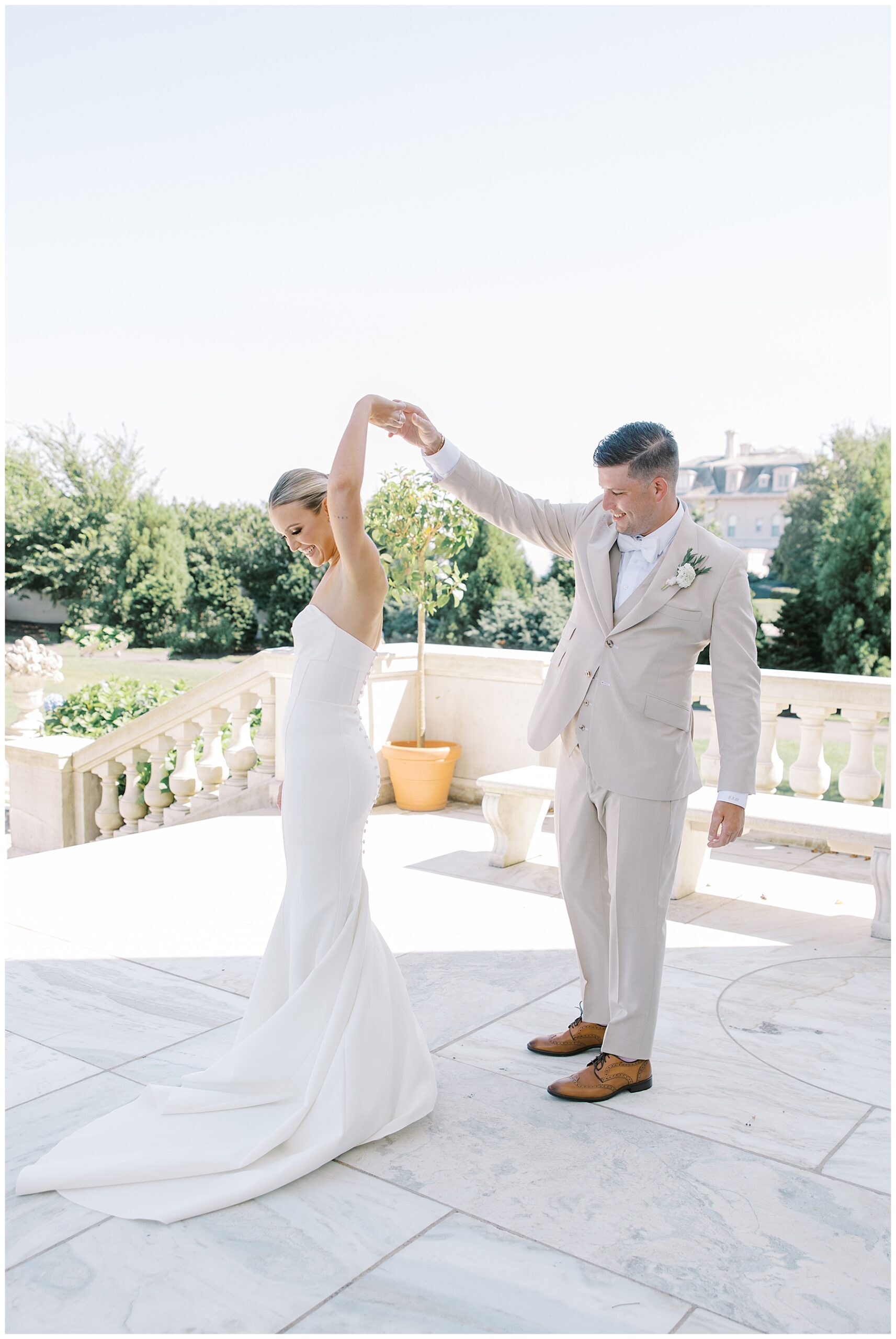 groom spins bride on patio of The Marble House