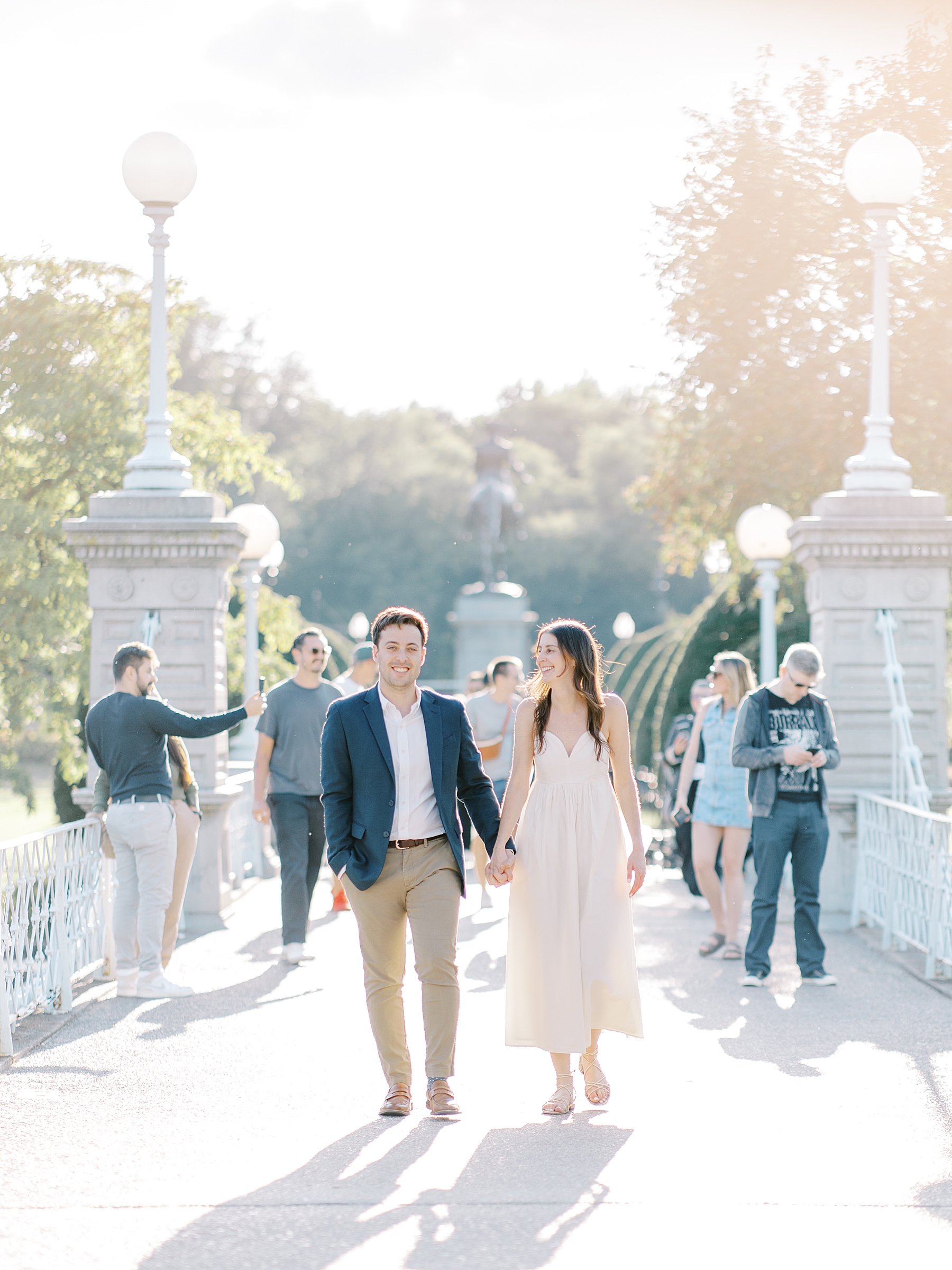 couple hold hands walk across bridge 